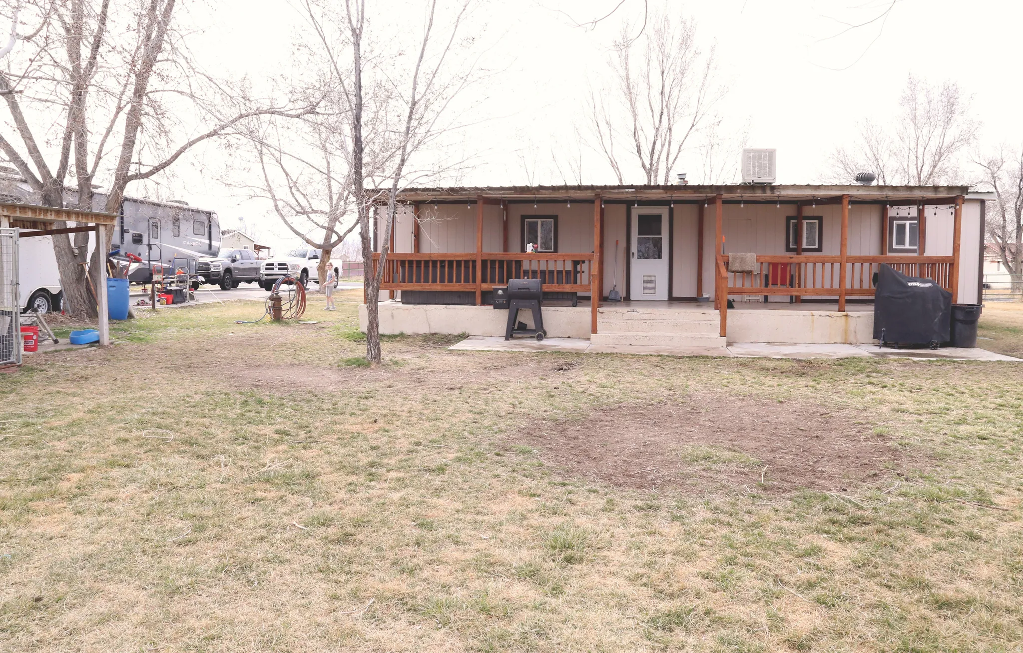Back of house featuring covered porch and a lawn