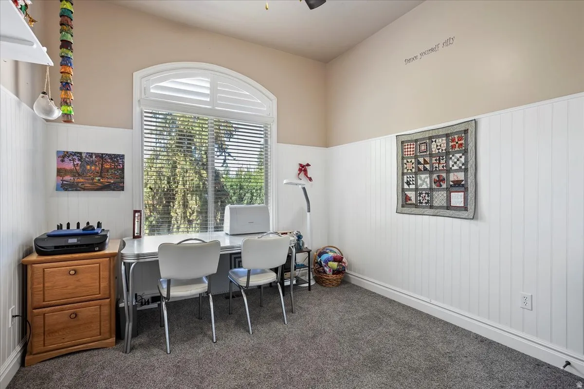 Office with wainscoting and dark colored carpet