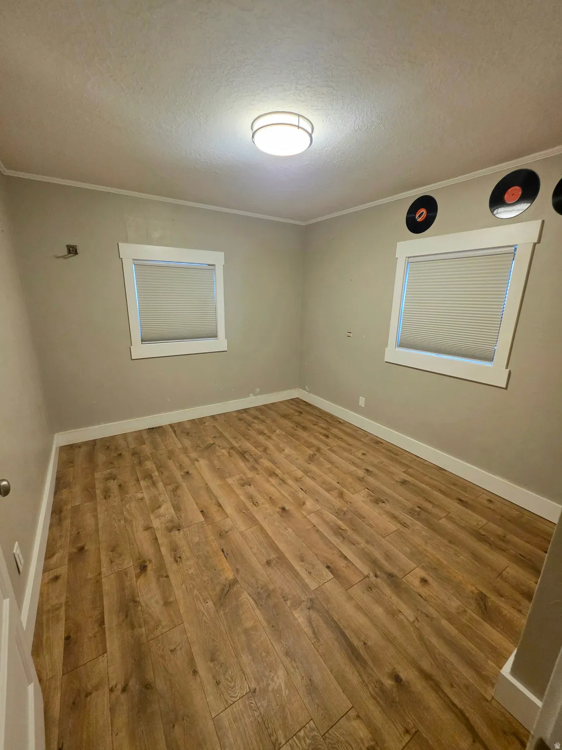 Unfurnished room with hardwood / wood-style floors, a textured ceiling, and ornamental molding