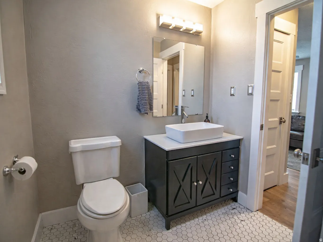 Bathroom featuring vanity, a textured wall, and light tile patterned flooring
