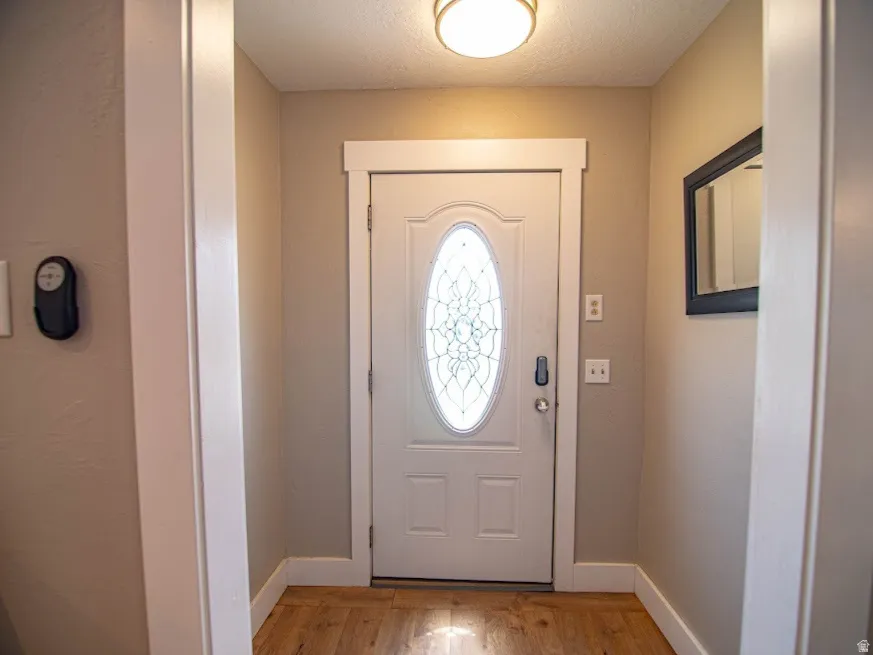 Foyer featuring light wood-style floors and a textured ceiling