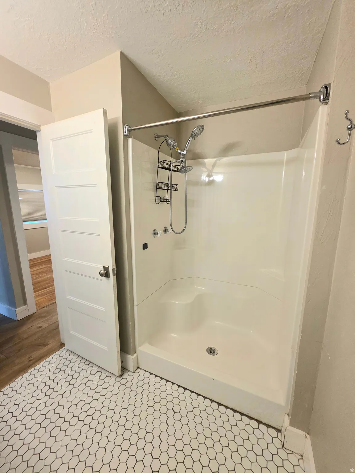Bathroom featuring a shower stall and a textured ceiling