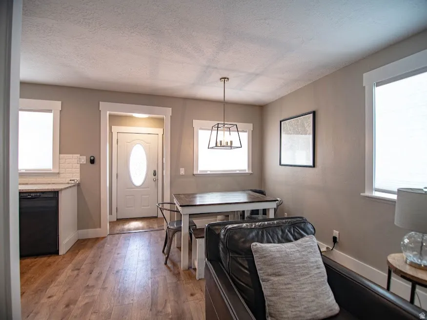 Dining room with hardwood / wood-style flooring, a textured ceiling, and healthy amount of natural light