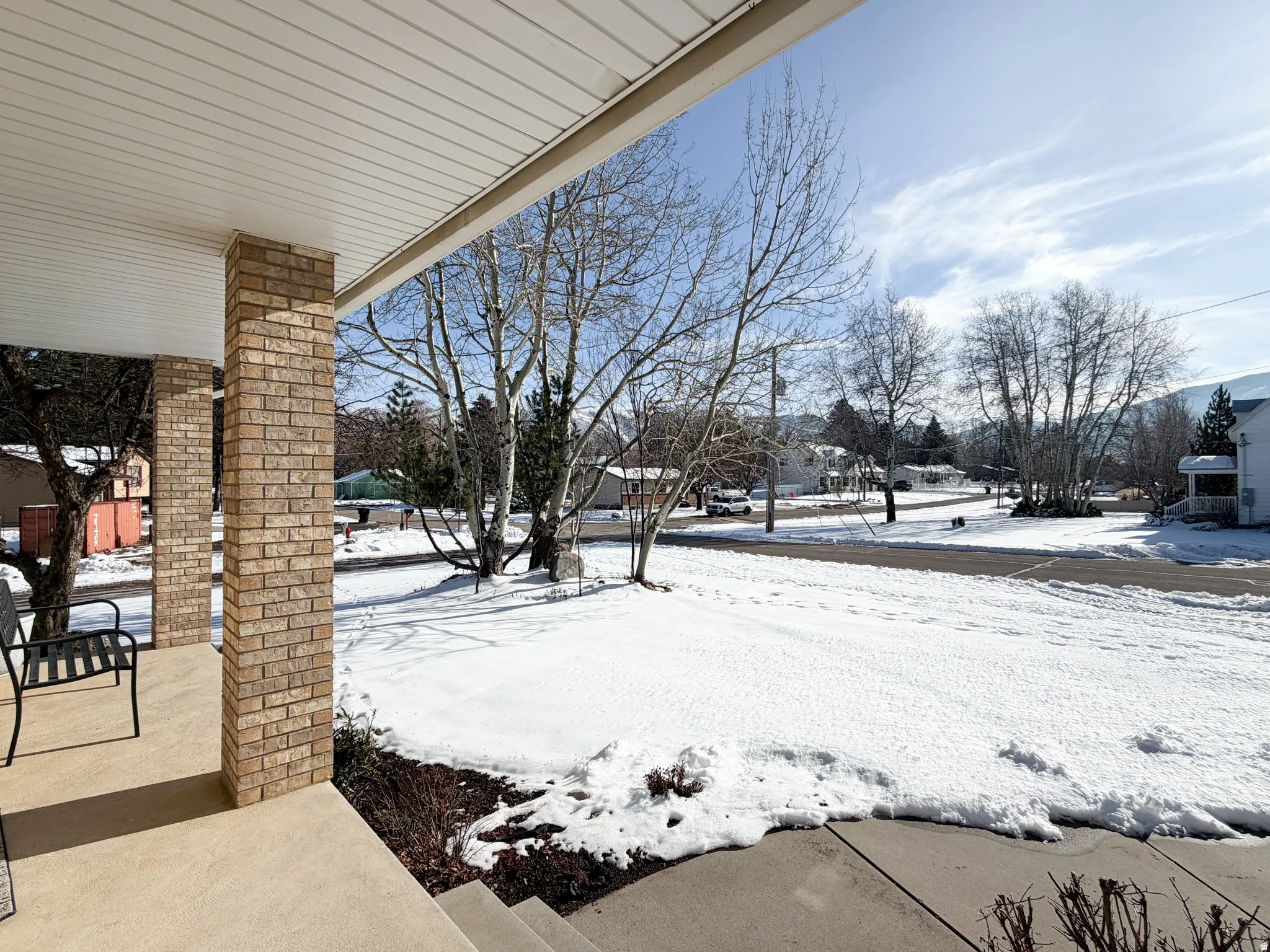 Snowy yard with covered porch