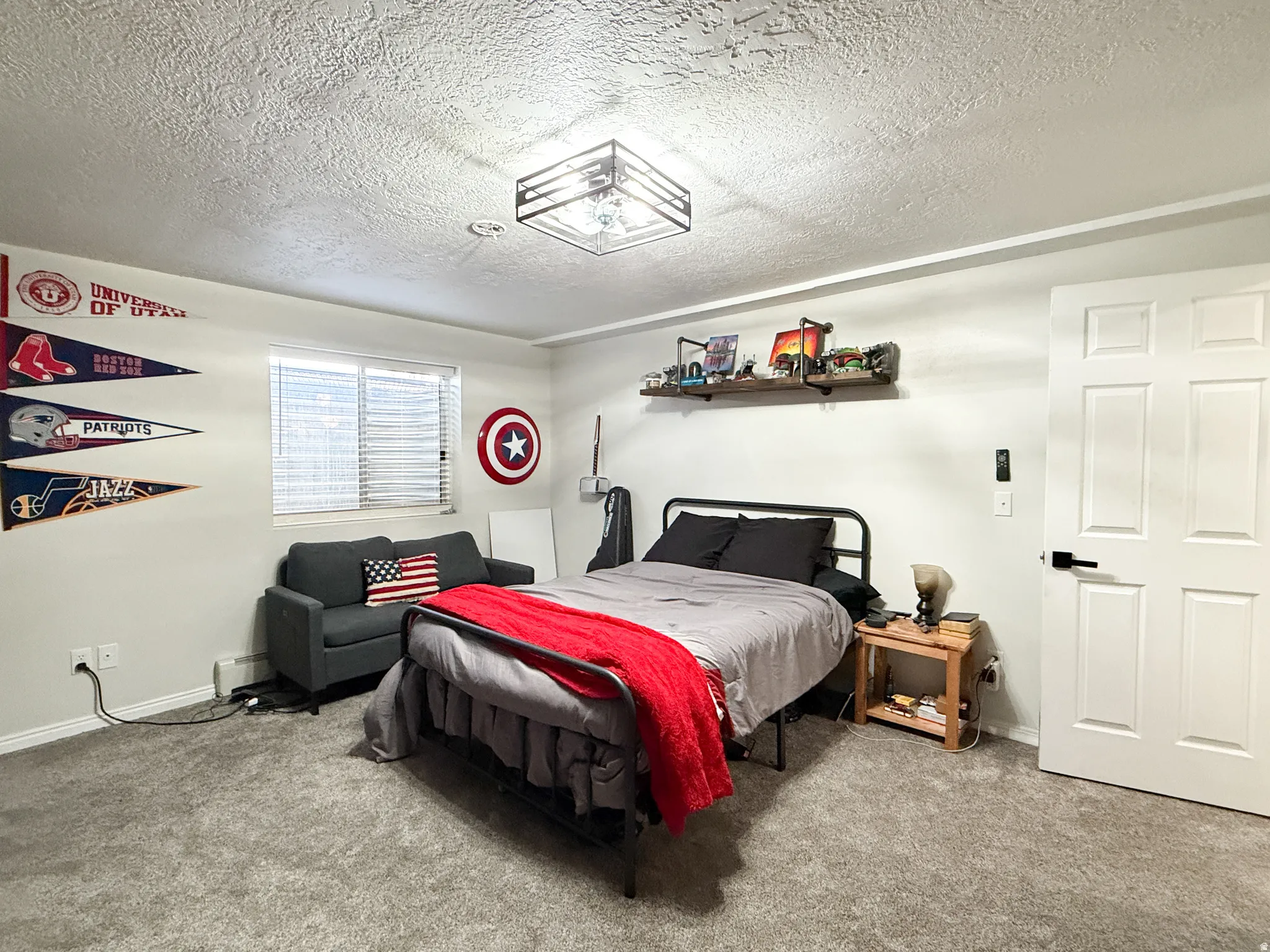 Carpeted bedroom with a textured ceiling and baseboard heating