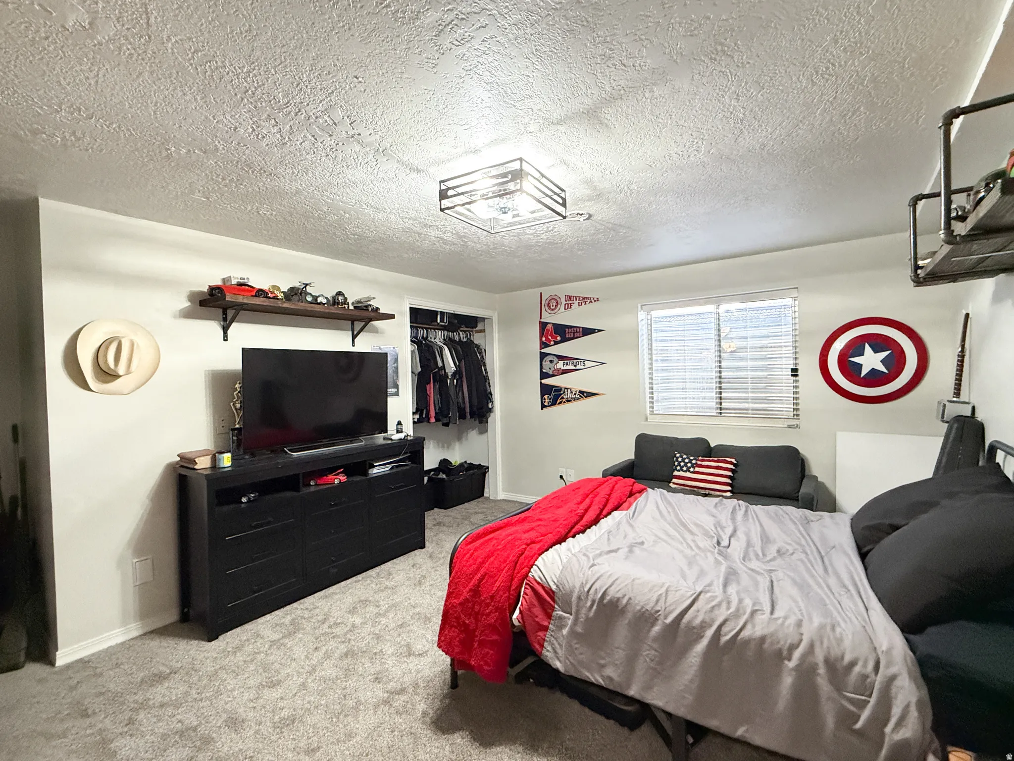 Carpeted bedroom featuring a textured ceiling and a closet