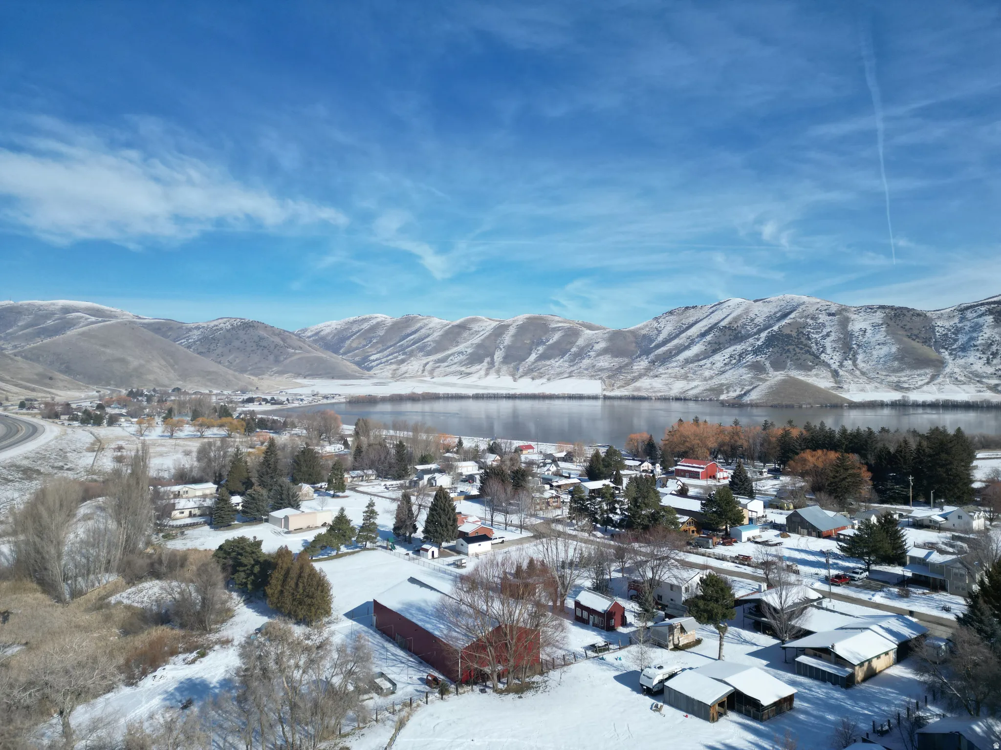 View of mountain backdrop featuring a large body of water and nearby suburban area