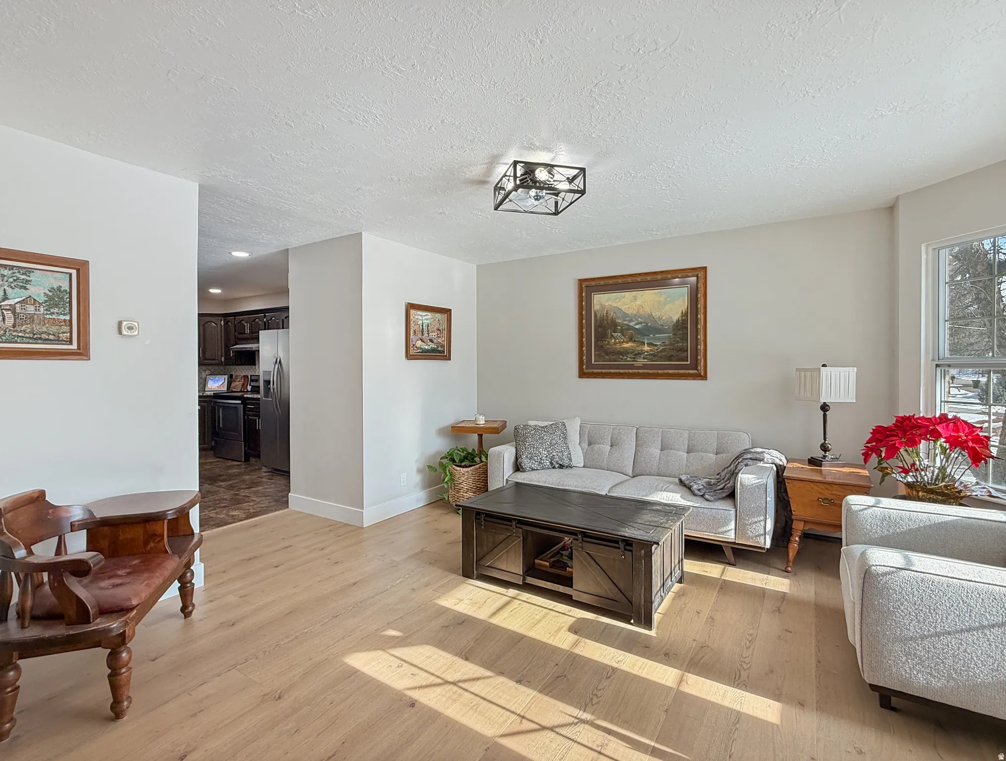 Living area with light wood-style flooring and a textured ceiling