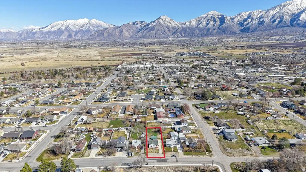 Aerial view of residential area featuring property boundaries highlighted and mountains