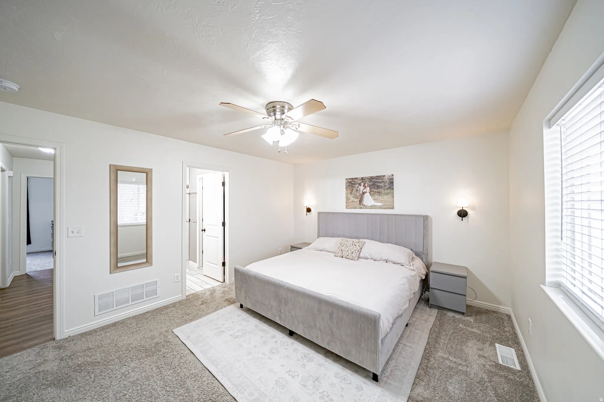 Carpeted bedroom with ceiling fan and baseboards