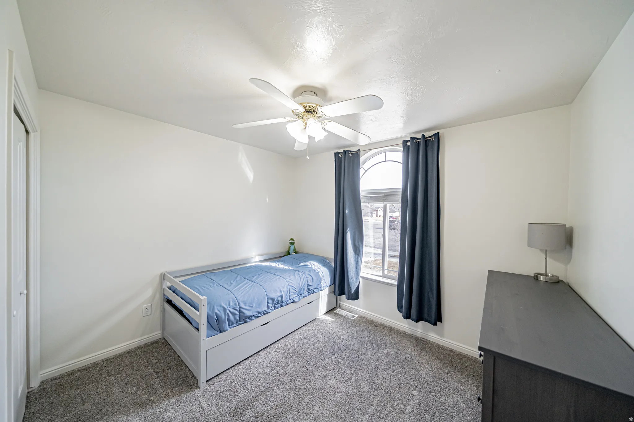 Bedroom featuring ceiling fan and dark colored carpet