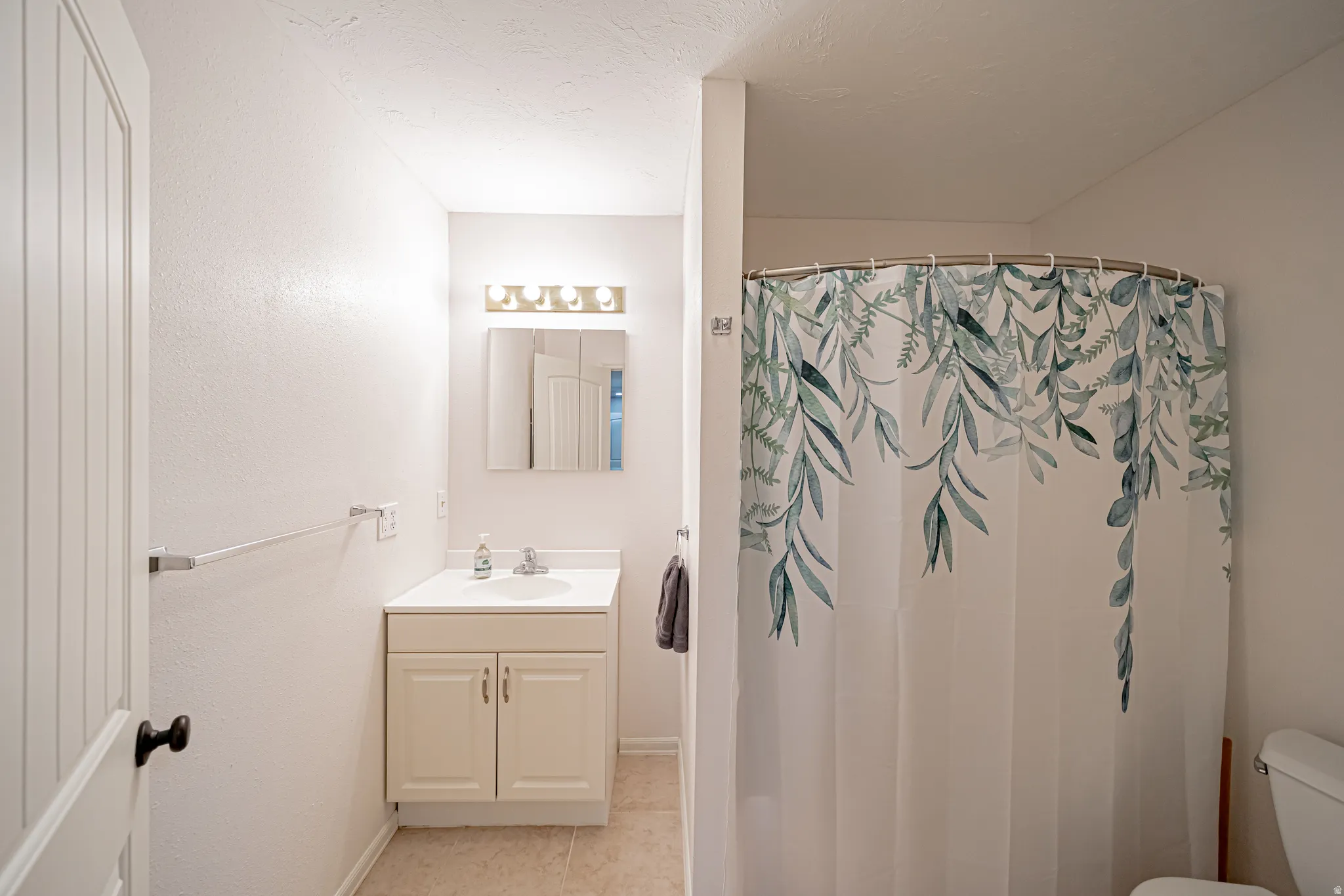 Bathroom featuring vanity, a shower with curtain, and light tile patterned flooring