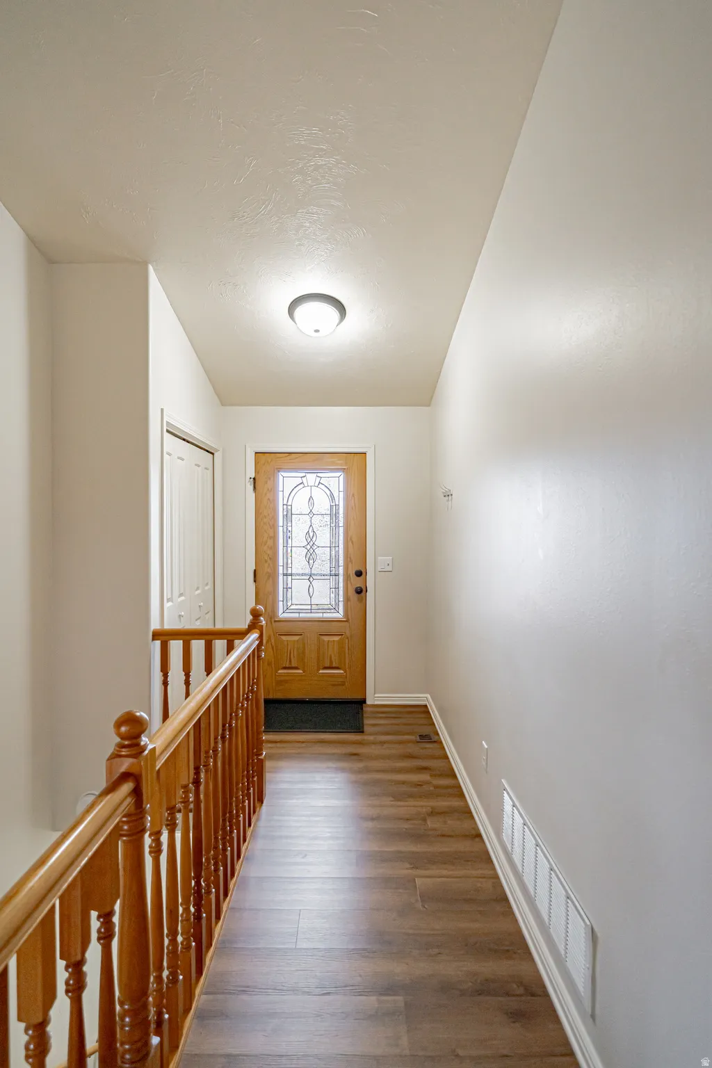 Entrance foyer with dark wood-style floors and a textured ceiling