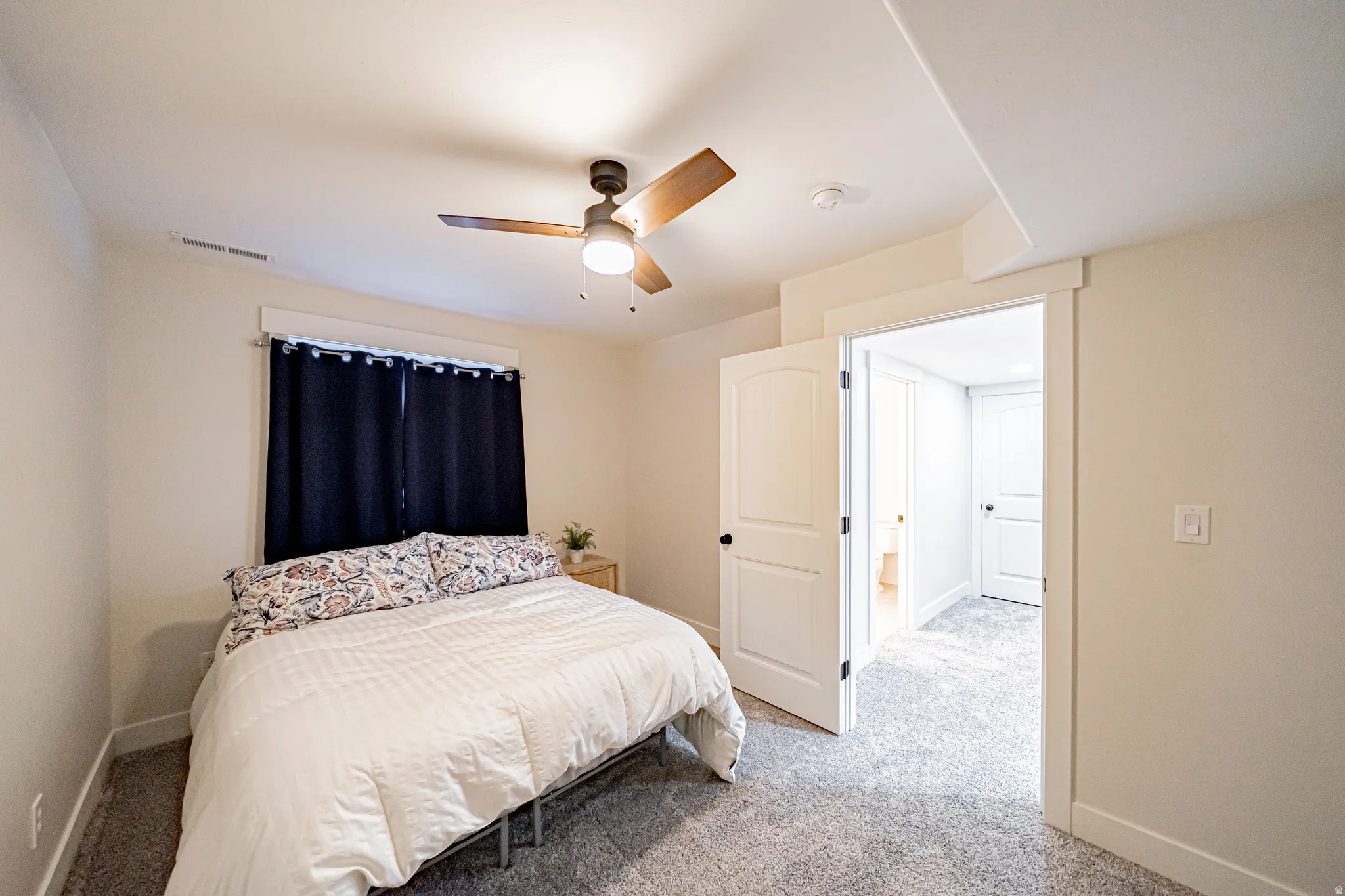 Carpeted bedroom featuring ceiling fan and baseboards