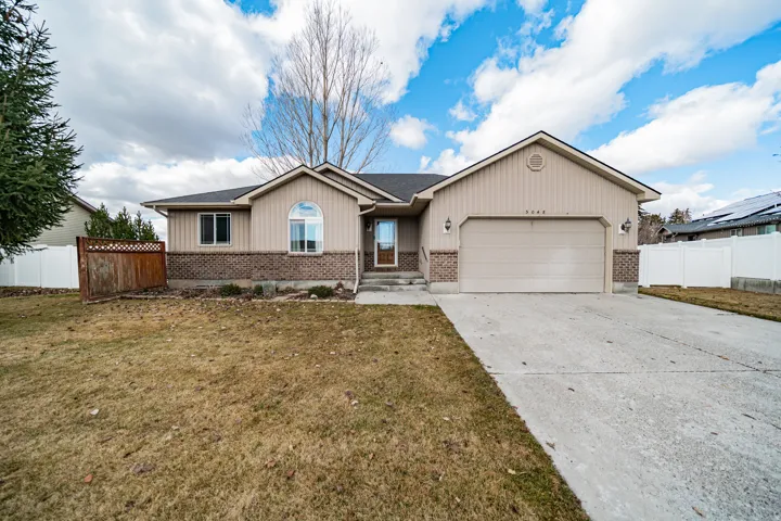 Ranch-style house with driveway, an attached garage, brick siding, and a shingled roof