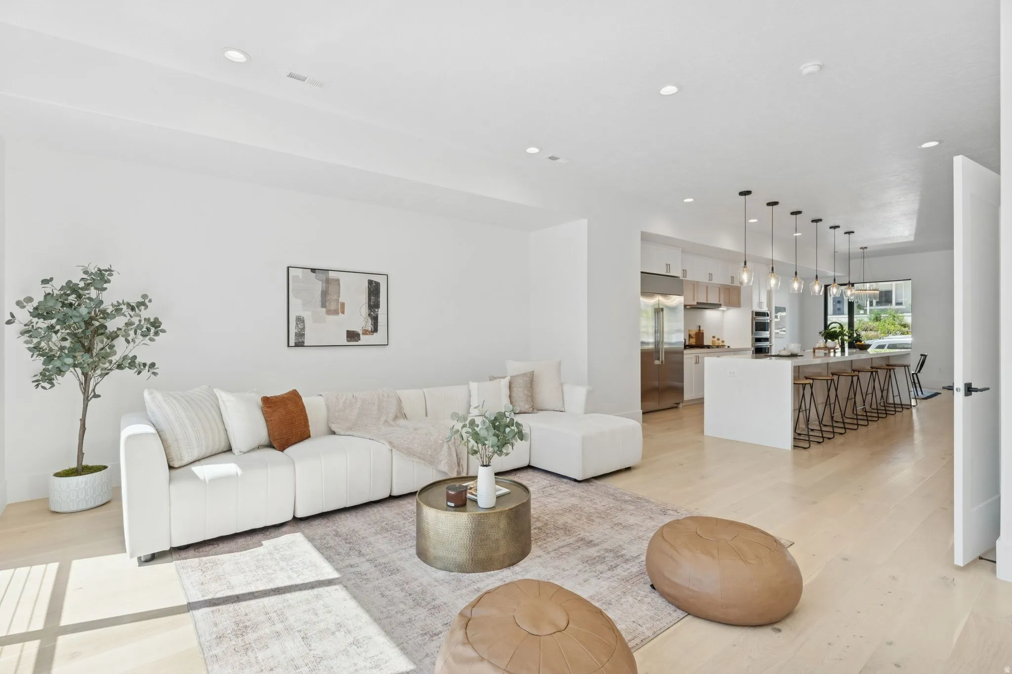 Living room with light wood-style flooring and recessed lighting