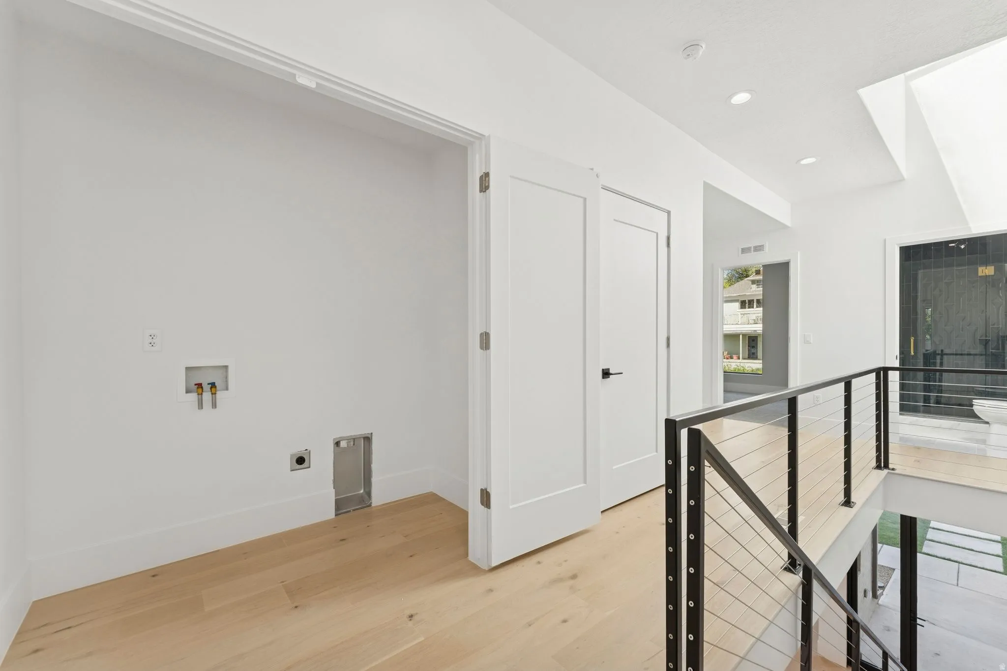 Hall featuring an upstairs landing, light wood finished floors, and recessed lighting