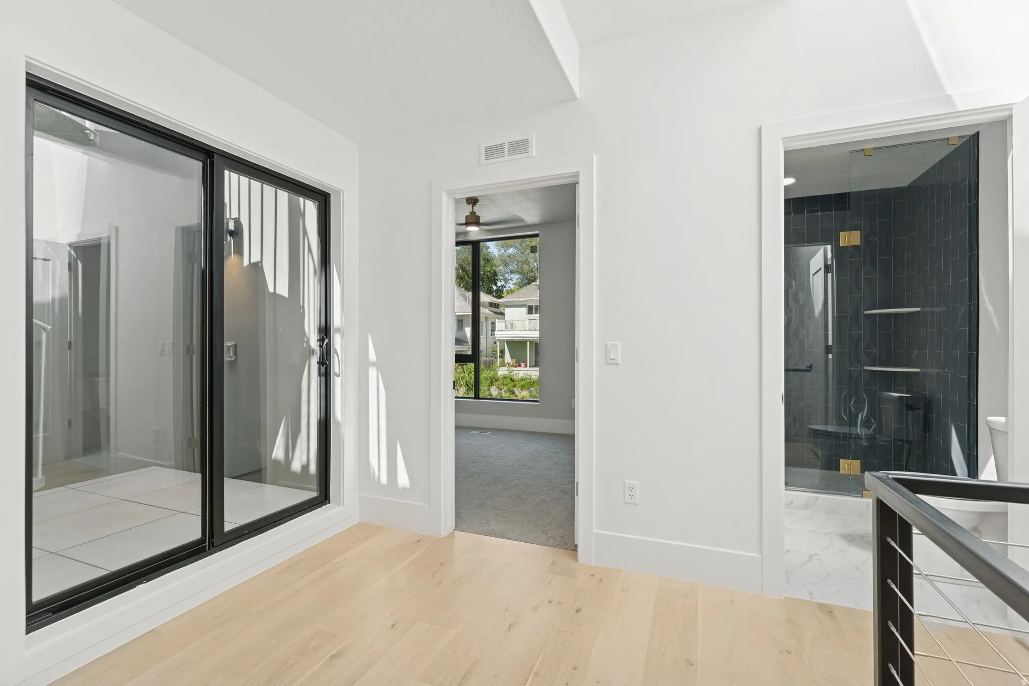 Full bathroom with light wood-style flooring, a shower stall, vanity, and a ceiling fan