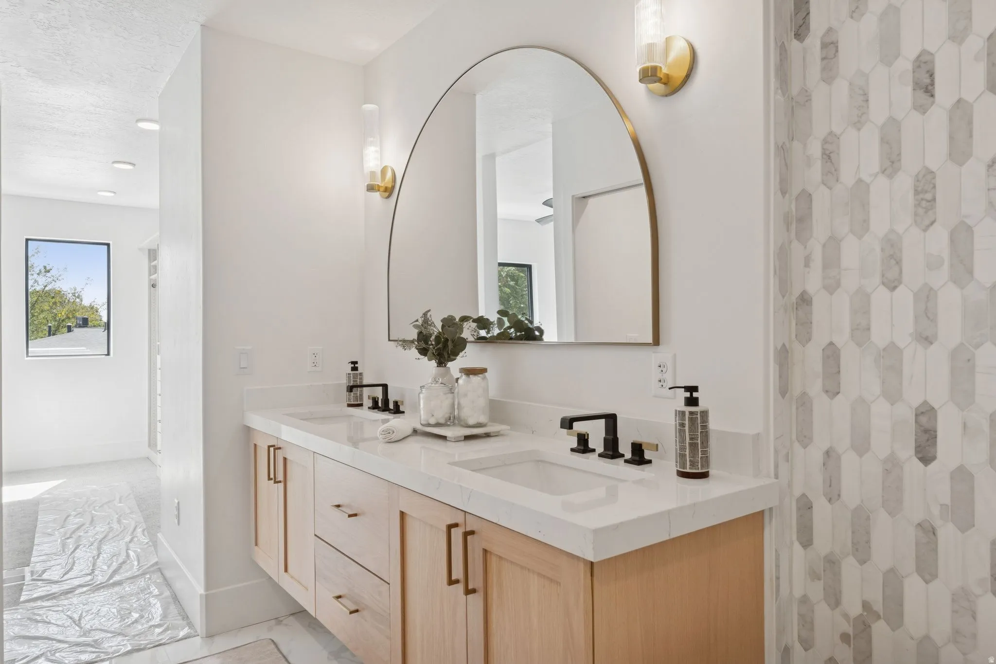 Full bath featuring double vanity, light marble finish floors, a shower with curtain, and a textured ceiling