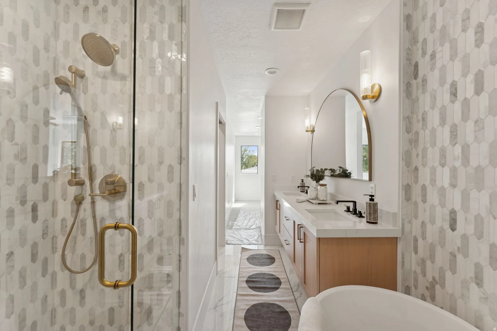 Full bathroom with double vanity, a soaking tub, a shower stall, and a textured ceiling