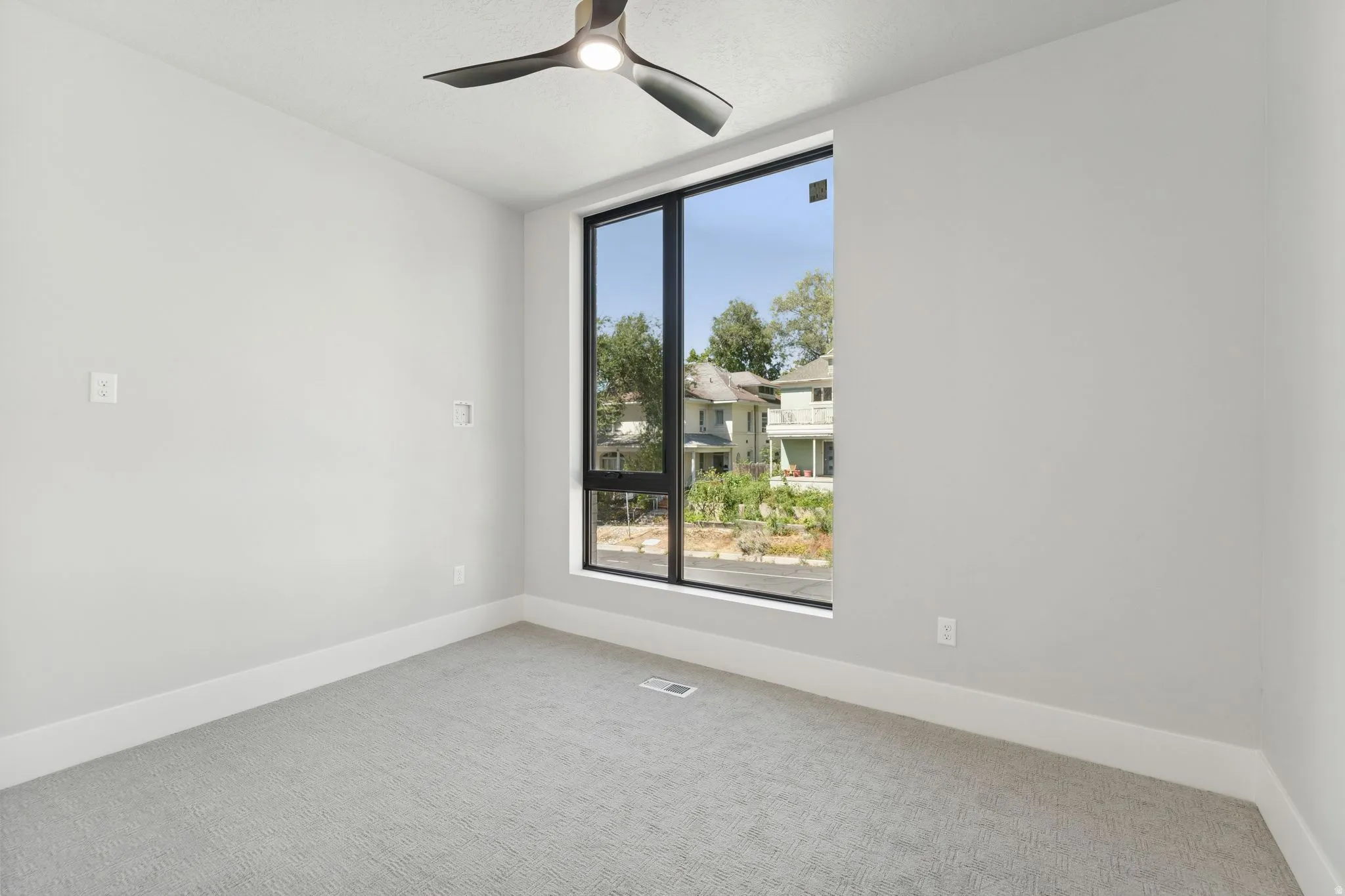 Spare room with light colored carpet and a ceiling fan