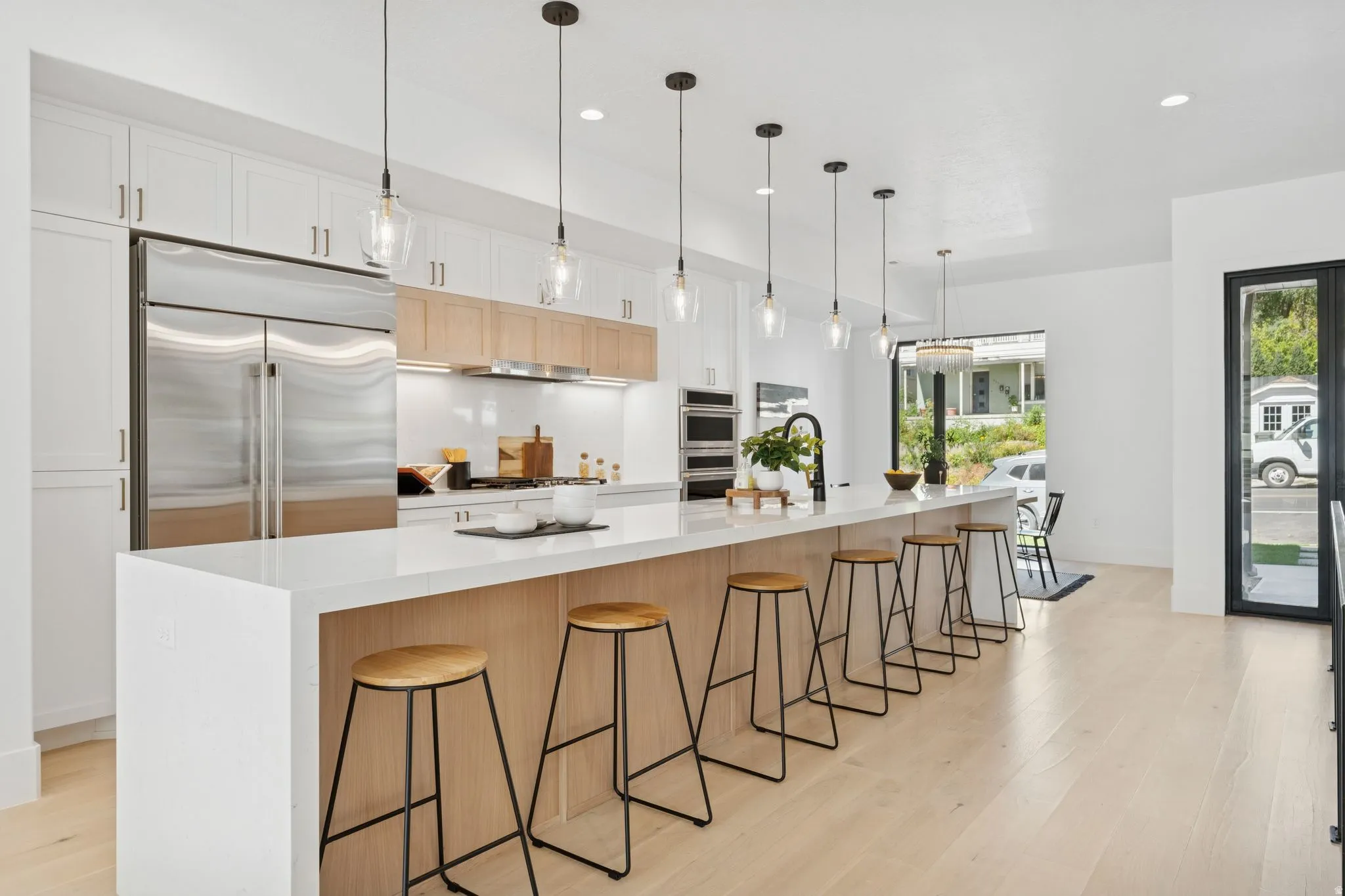 Kitchen featuring a kitchen breakfast bar, a spacious island, light wood finished floors, and dual tone cabinets