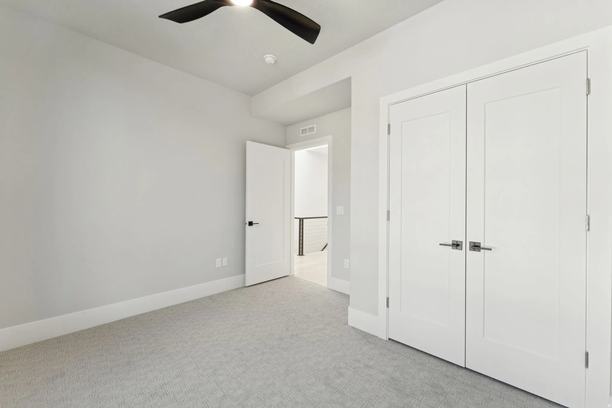 Unfurnished bedroom featuring light colored carpet, ceiling fan, and a closet