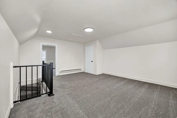 Bonus room with carpet floors and baseboard heating