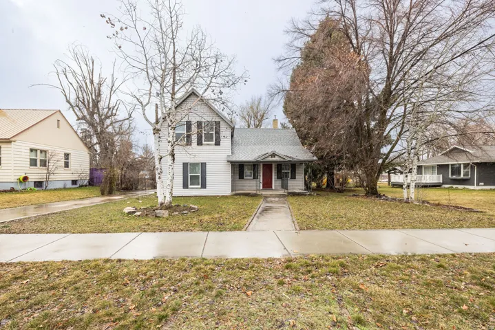 View of front of property featuring a front yard and a chimney