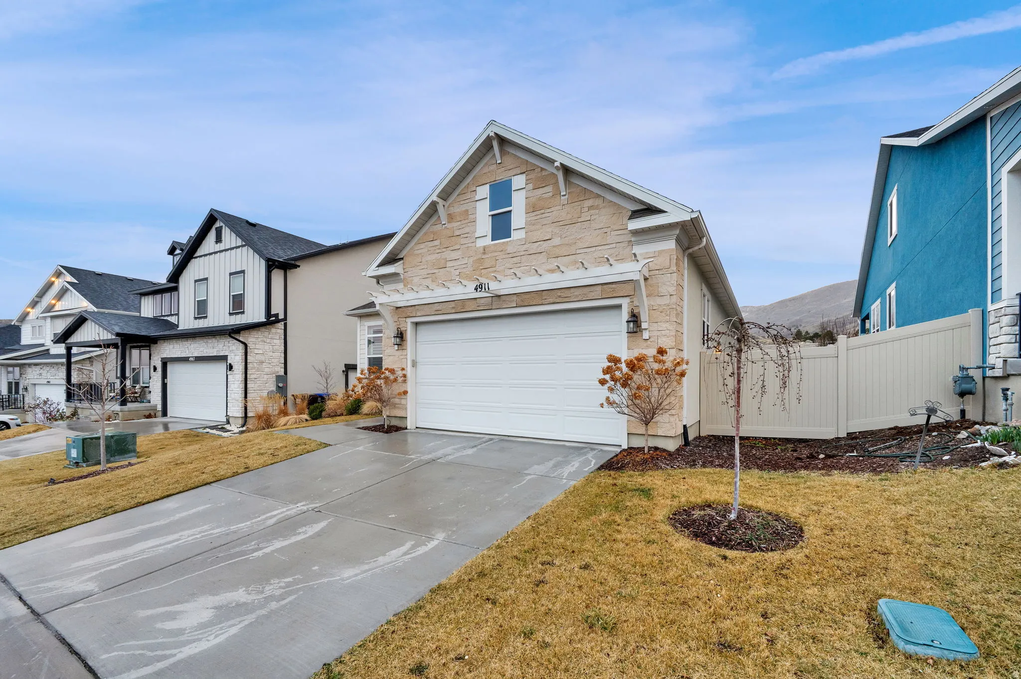 View of front of property featuring concrete driveway, a garage, and stone siding