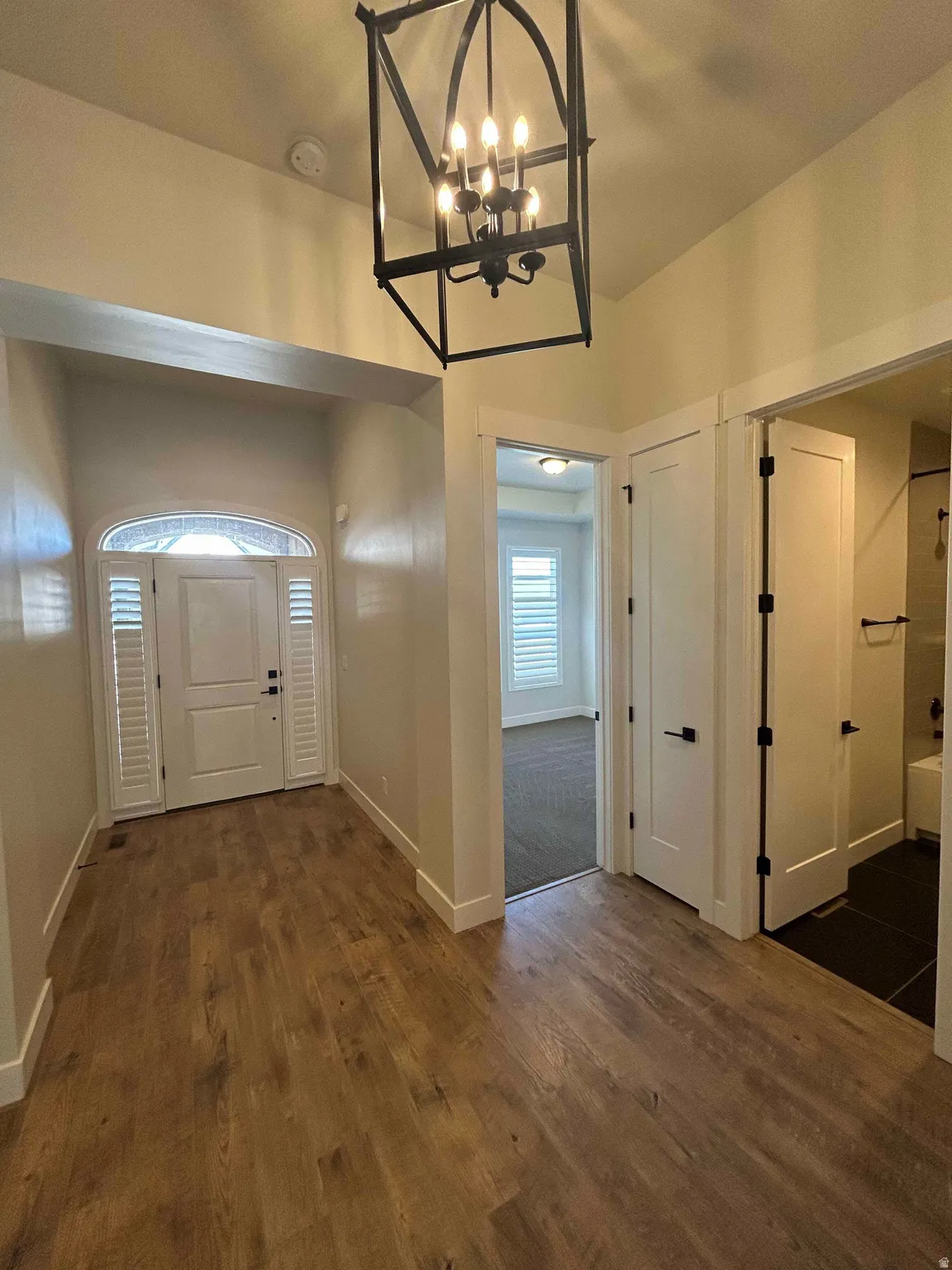 Entryway with hanging lights and dark wood-style floors