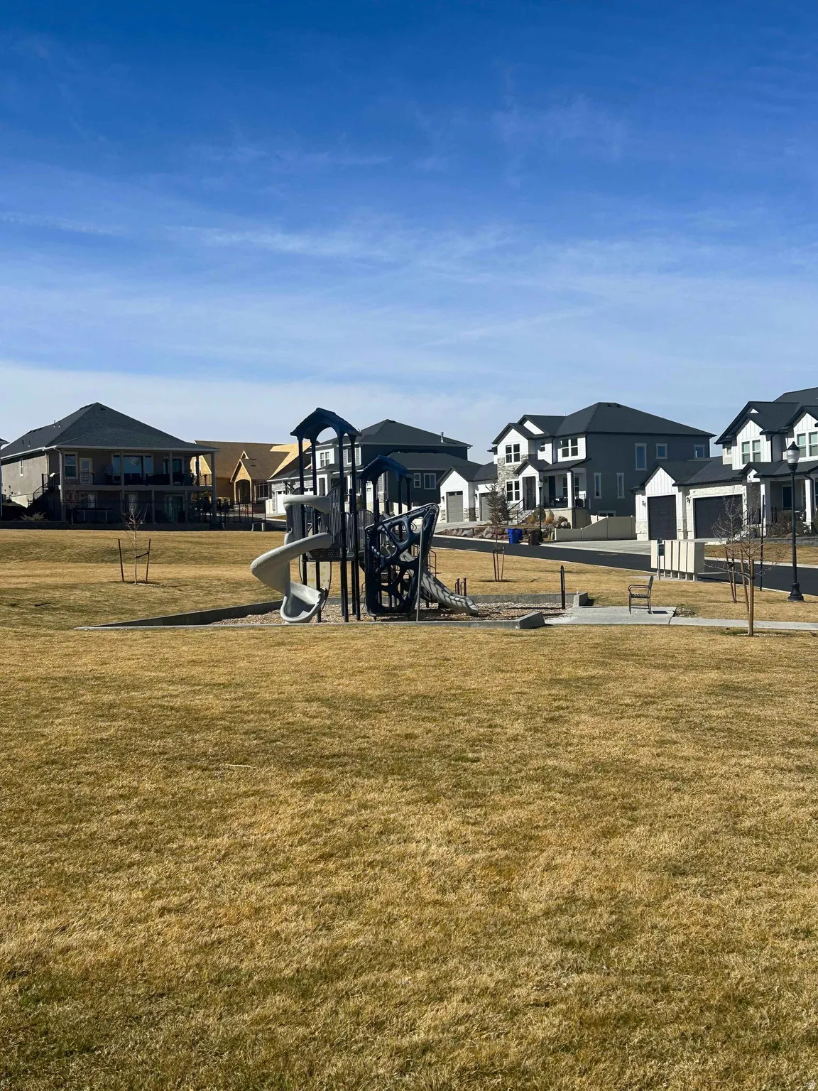 Community play area with a residential view and a lawn