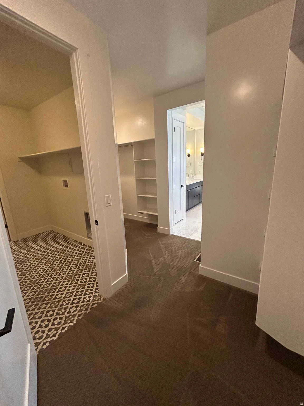 Hallway with dark carpet and baseboards