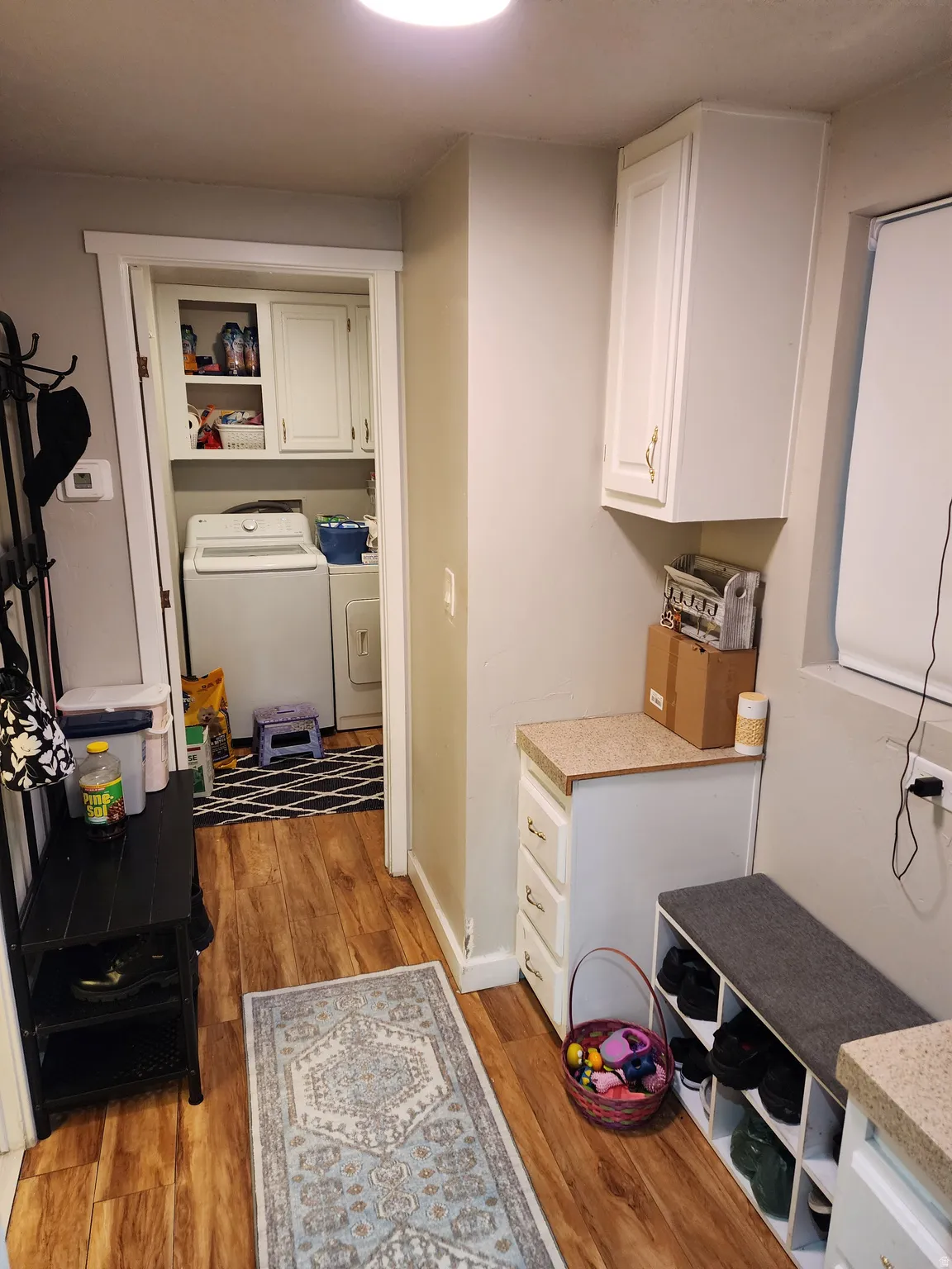 Laundry room featuring light wood-style floors, cabinet space, and washing machine and dryer