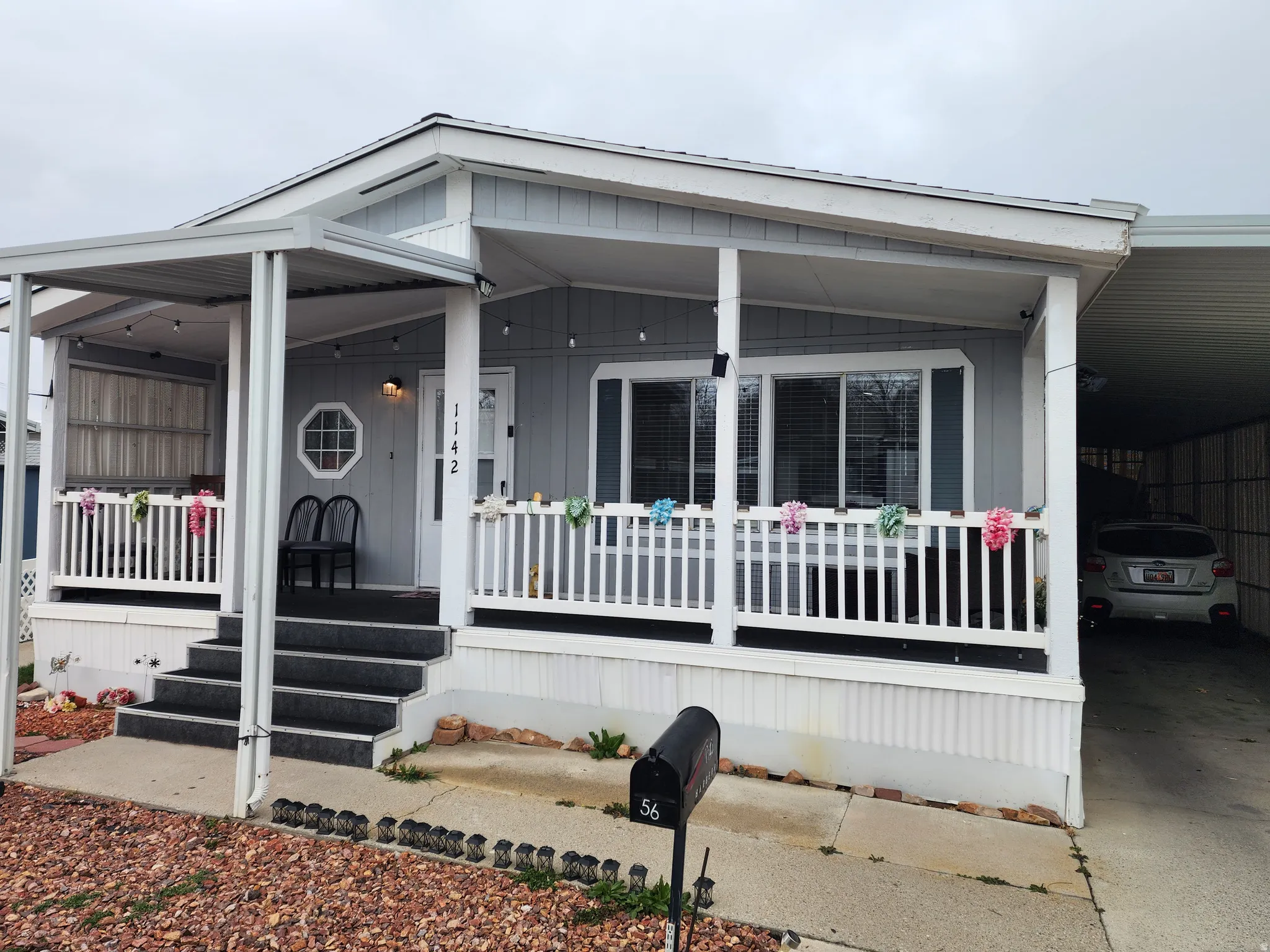Manufactured / mobile home featuring covered porch and a carport