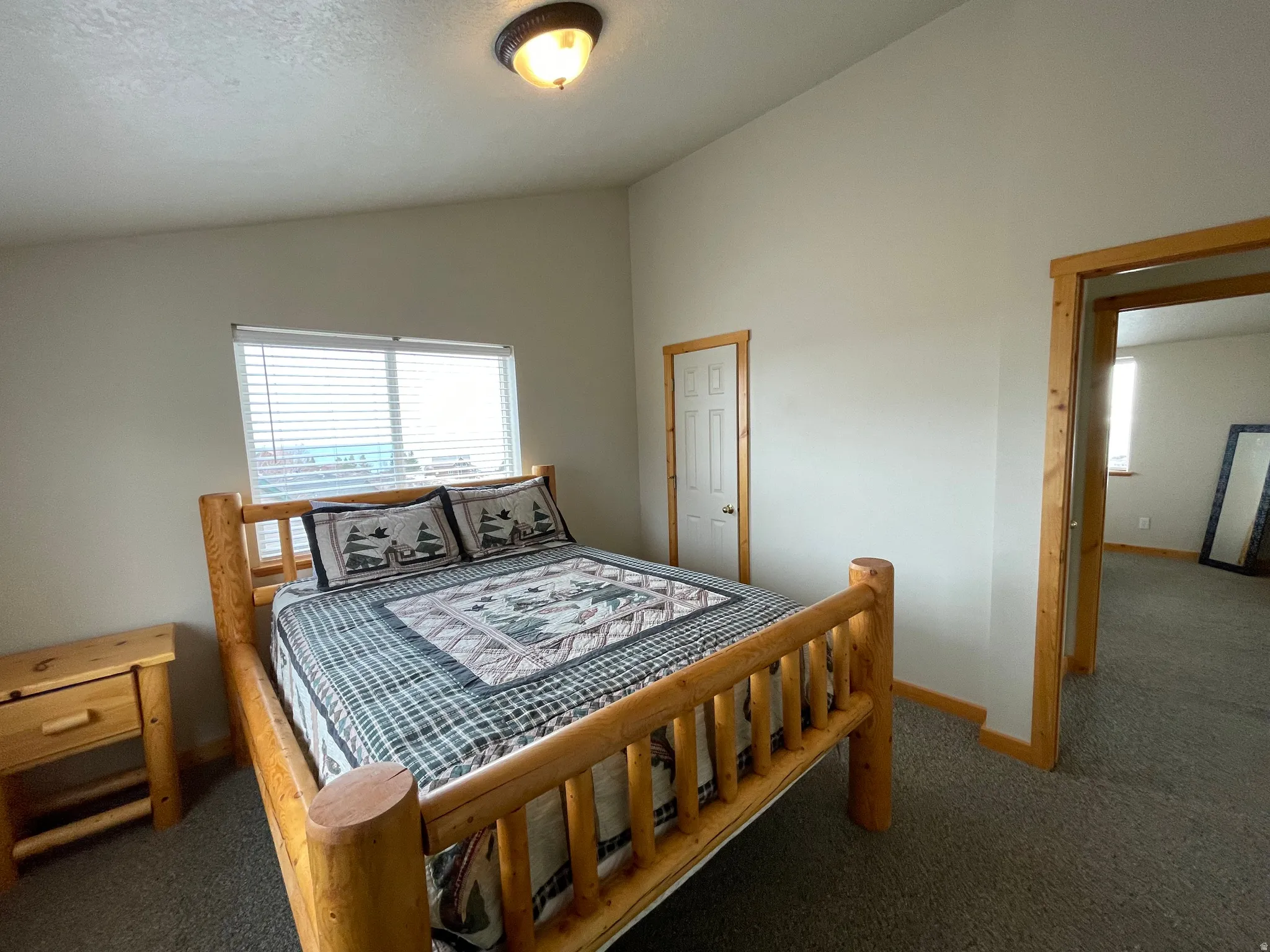 Bedroom featuring vaulted ceiling and carpet flooring