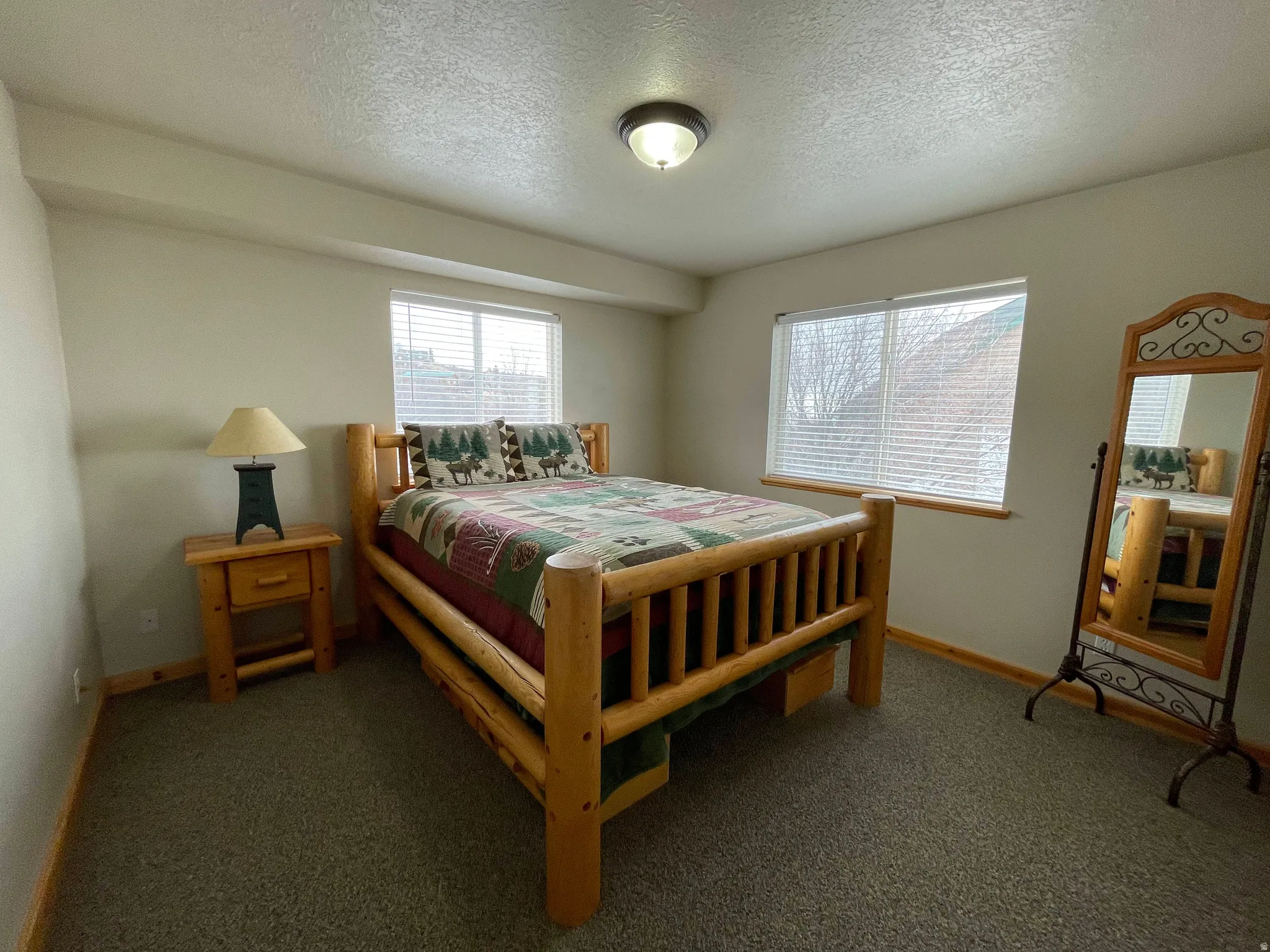 Carpeted bedroom with a textured ceiling and baseboards