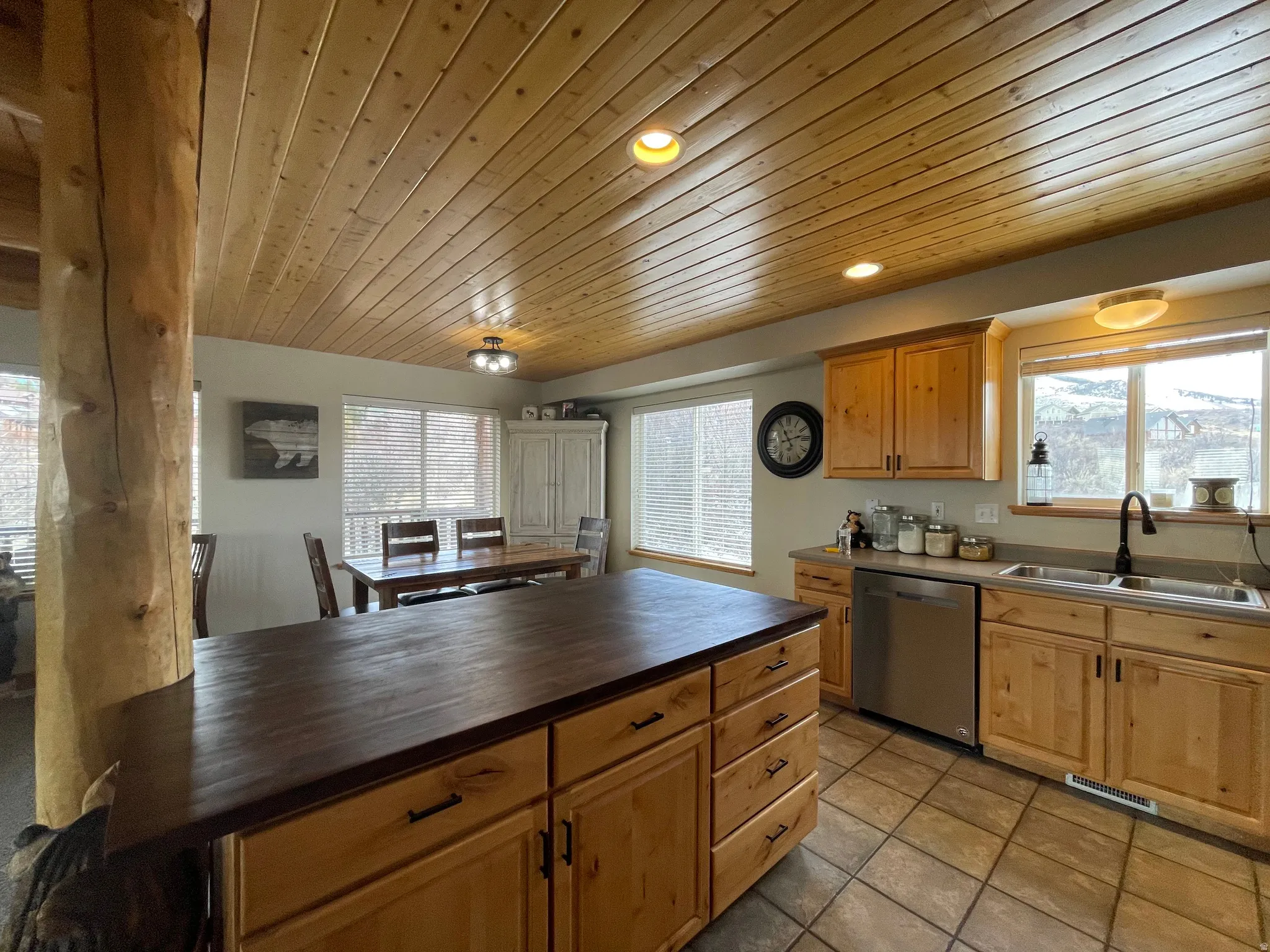 Kitchen with stainless steel dishwasher, wooden ceiling, recessed lighting, plenty of natural light, and light tile patterned floors