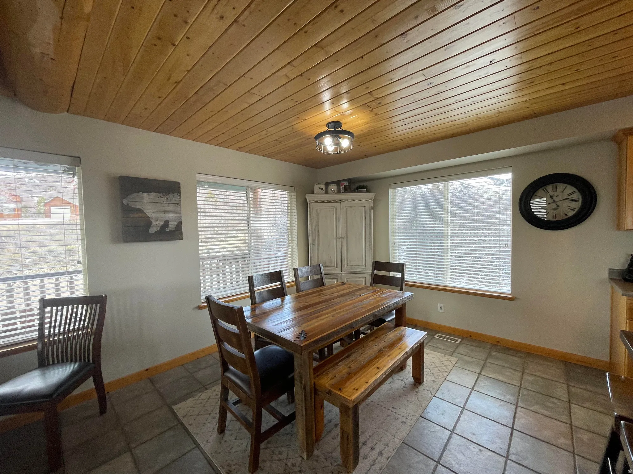 Dining space with wooden ceiling and light stone finish flooring