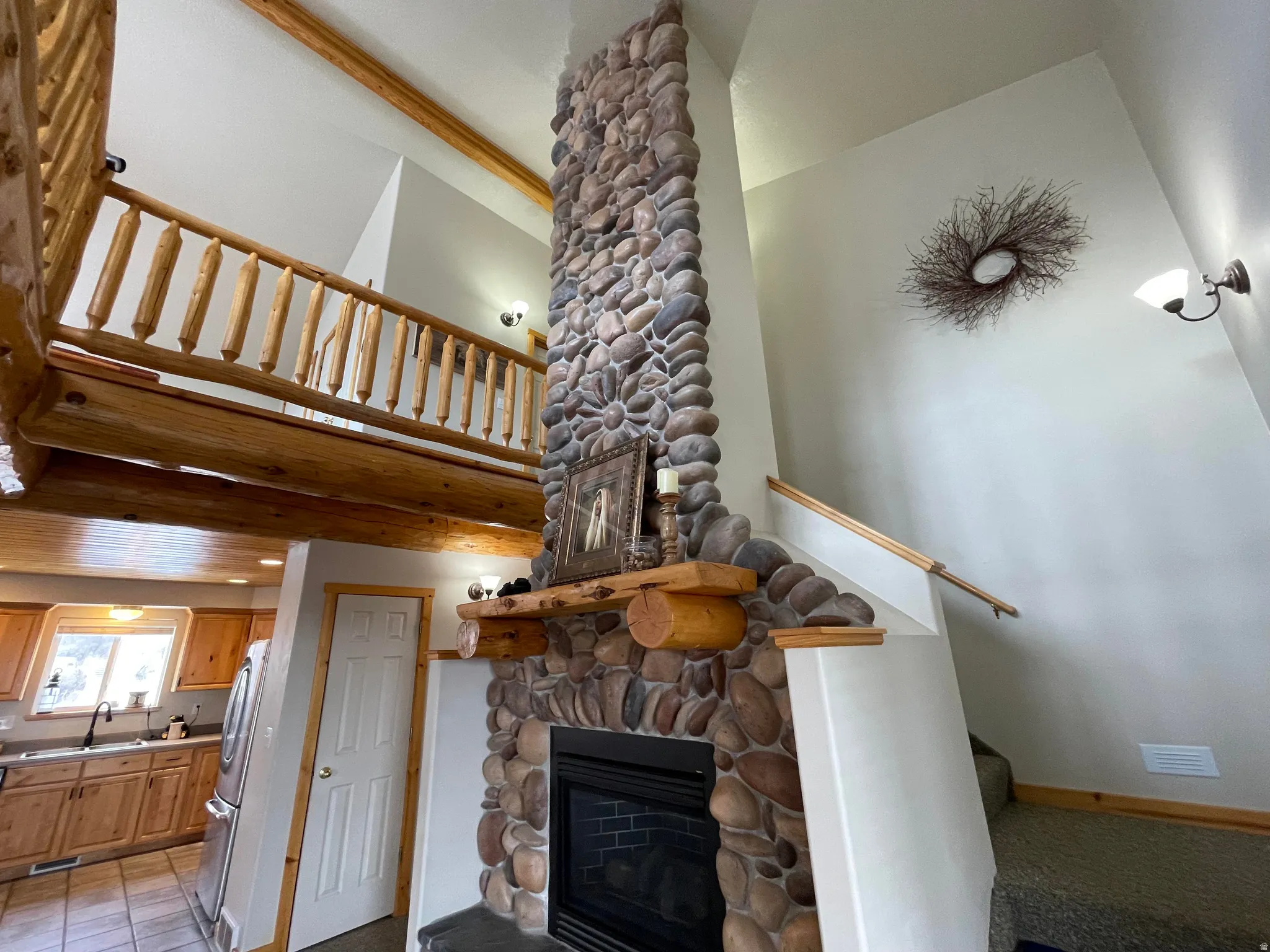 Living room with a stone fireplace and a high ceiling