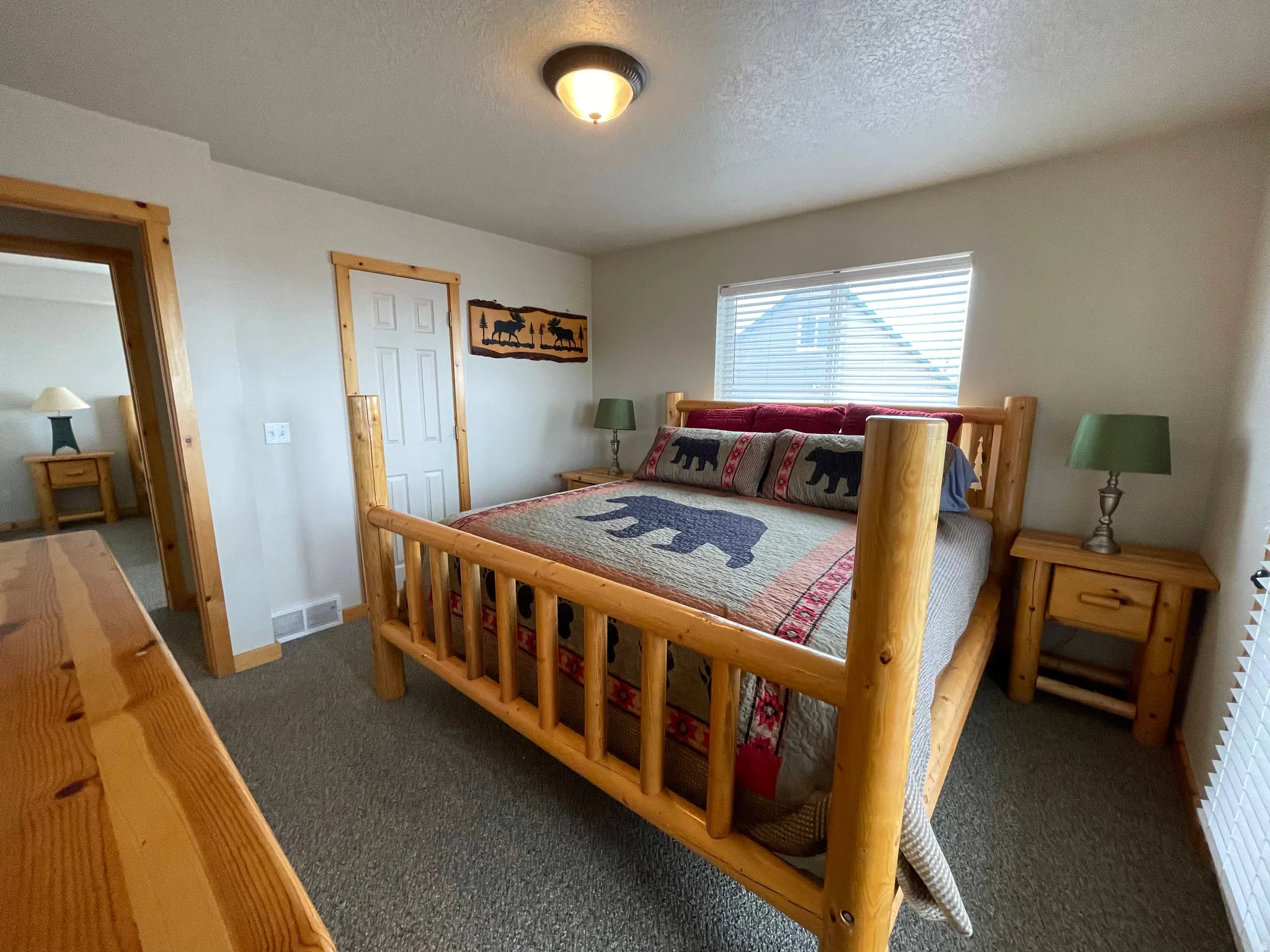 Bedroom featuring dark carpet and a textured ceiling