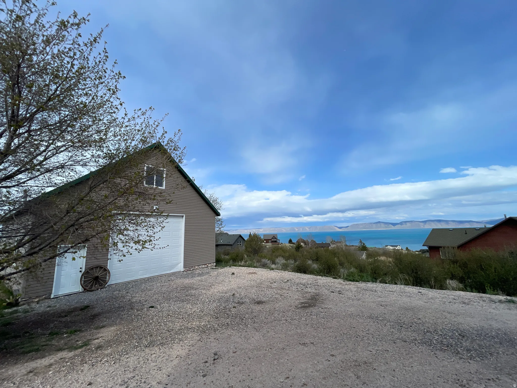 View of home's exterior featuring a mountain view, an outdoor structure, gravel driveway, and a garage