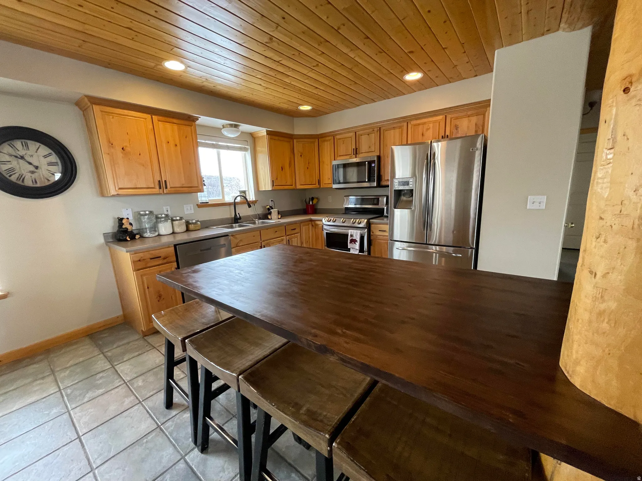 Kitchen featuring stainless steel appliances, recessed lighting, wood ceiling, wood finish cabinets, and a peninsula