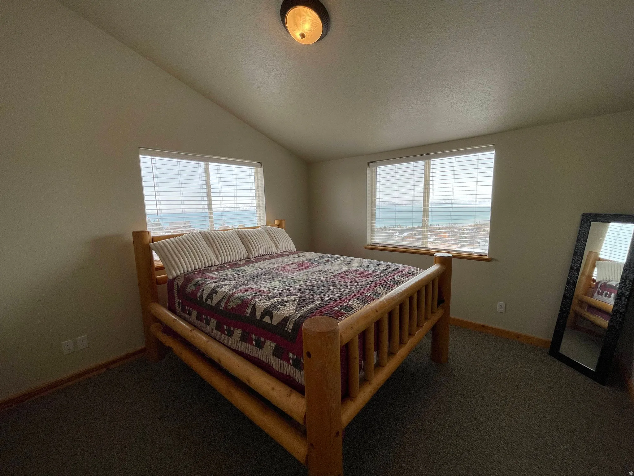 Bedroom featuring multiple windows and dark colored carpet