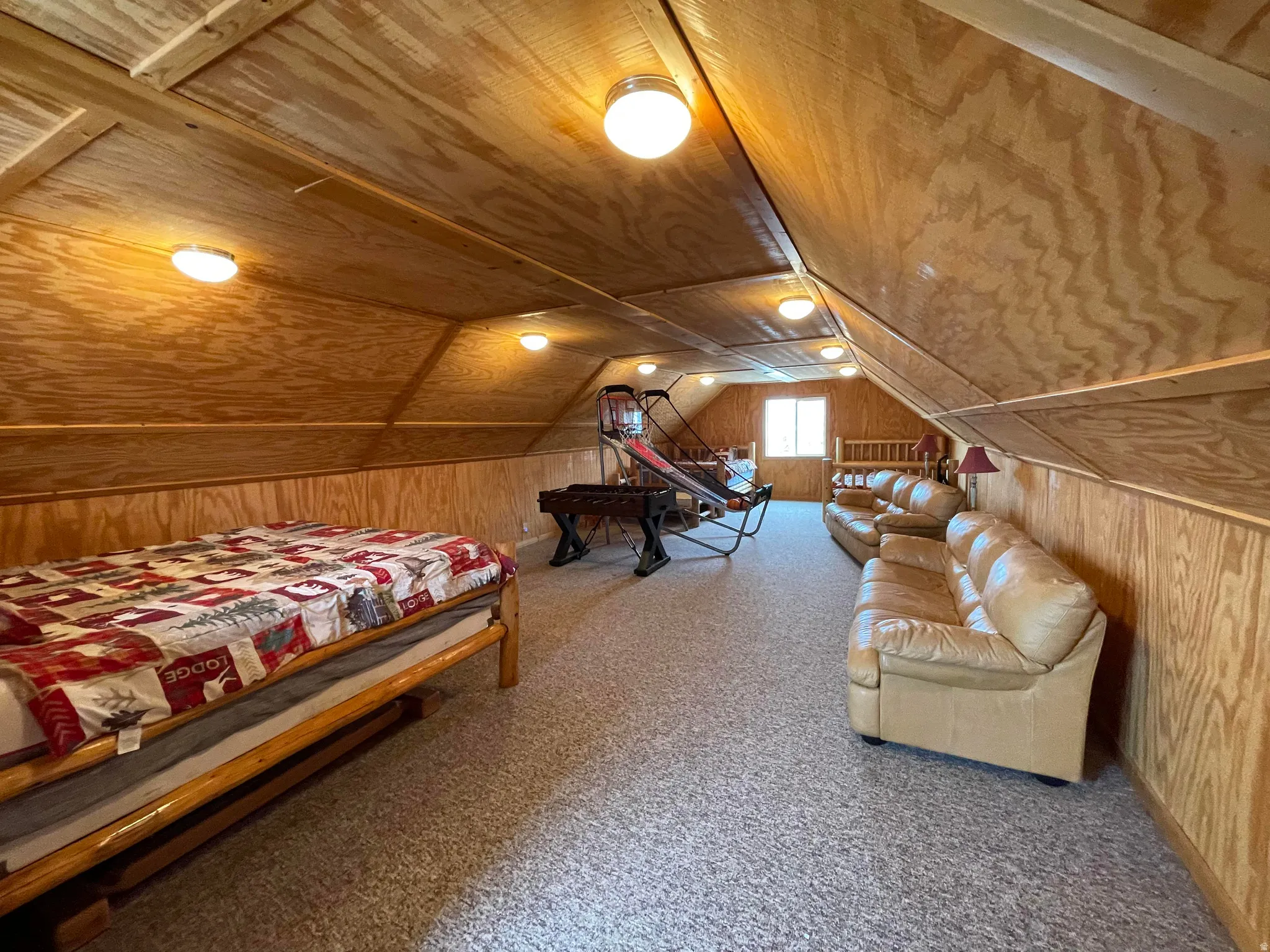Carpeted bedroom featuring wood walls and wood ceiling
