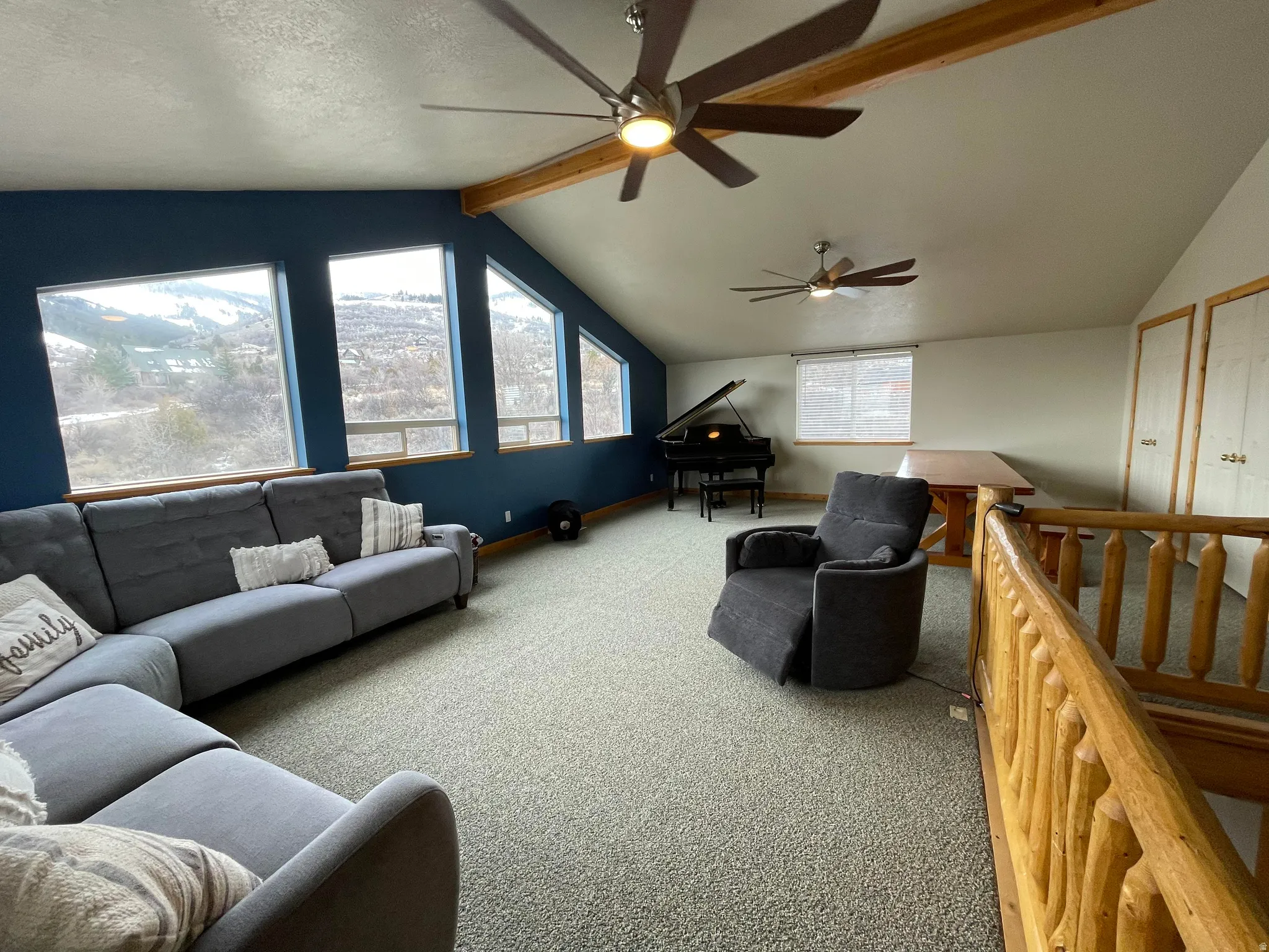 Carpeted living room with beam ceiling and a ceiling fan