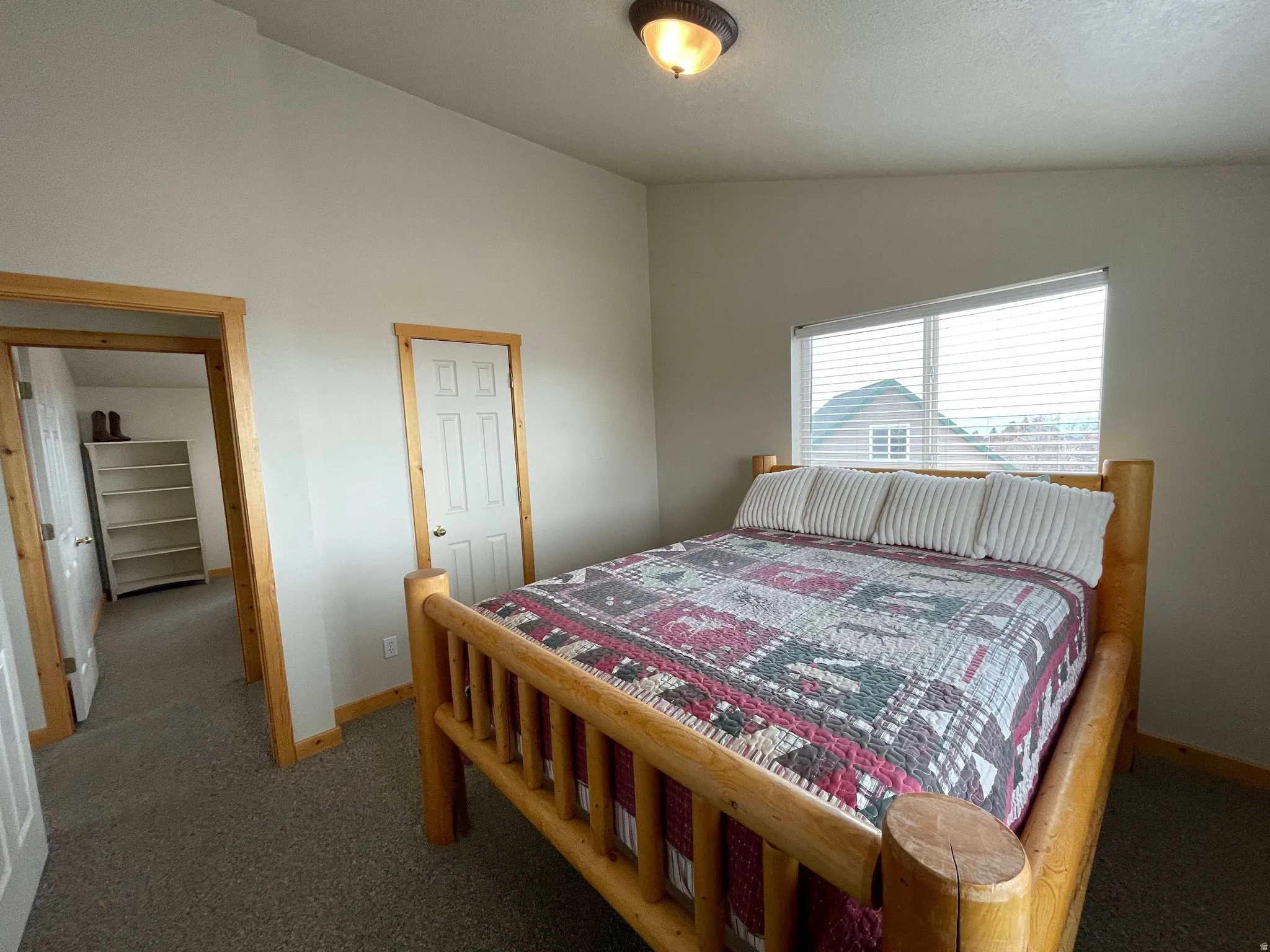 Bedroom with lofted ceiling and carpet floors