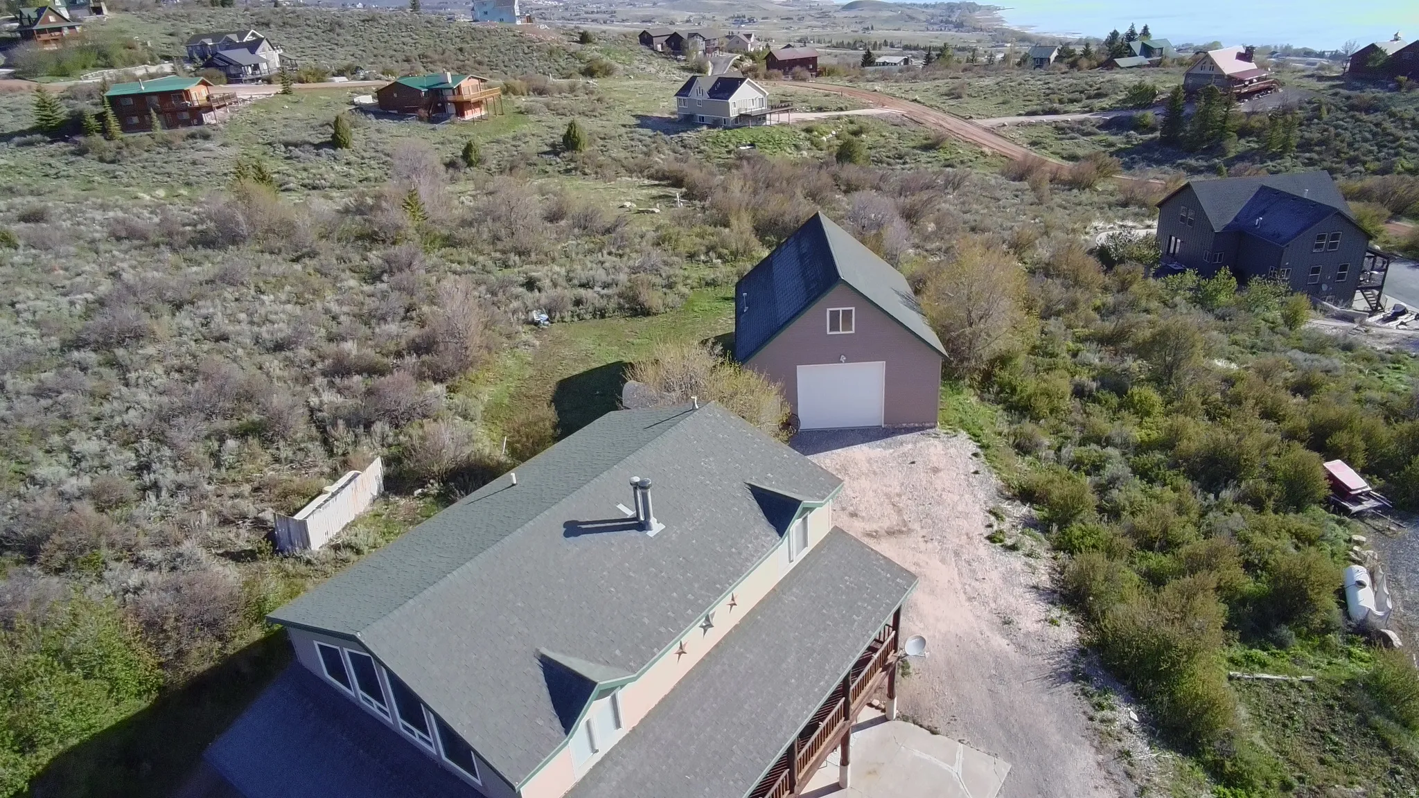 Aerial perspective showcasing a property with a residential structure and a detached garage
