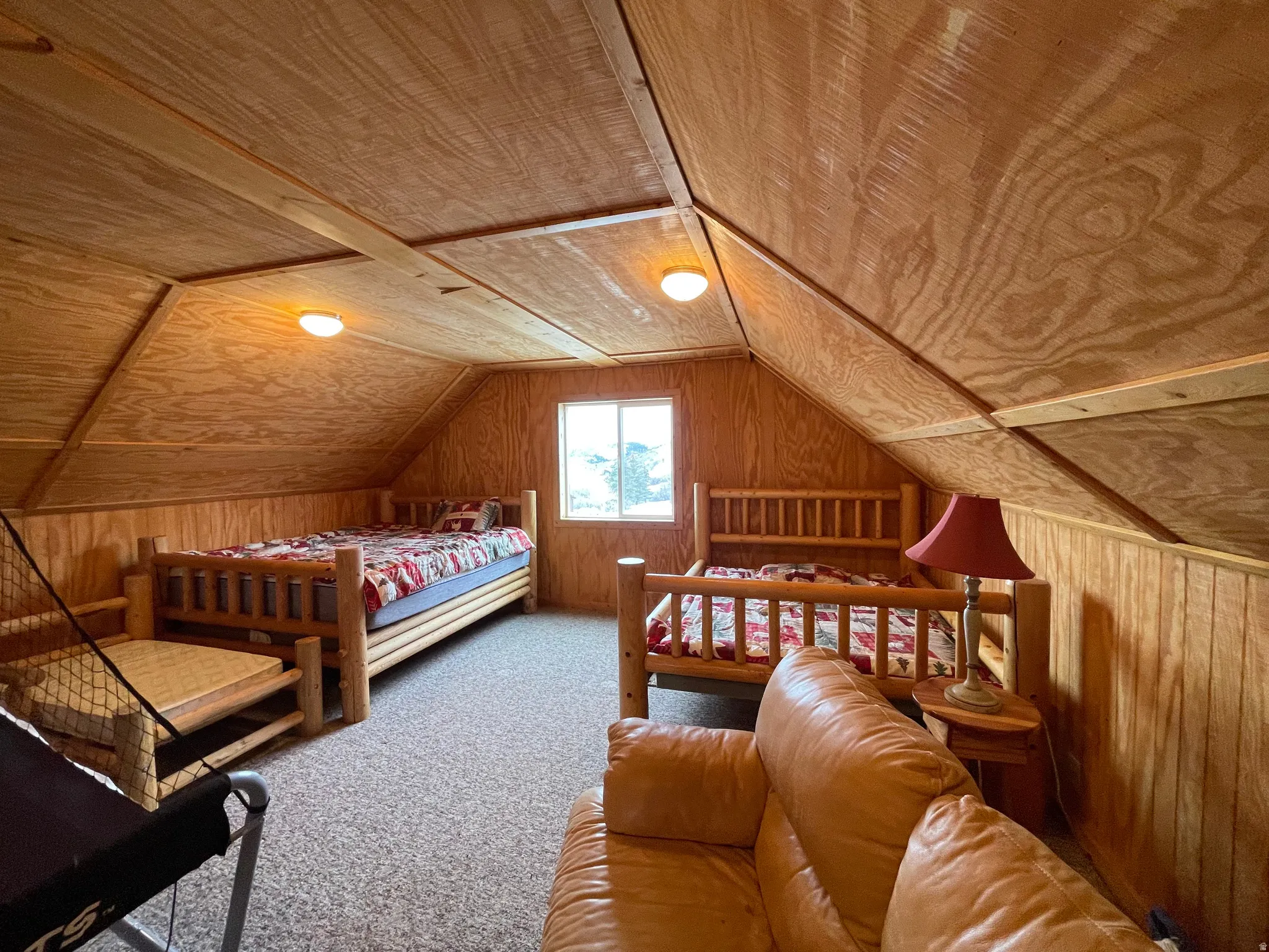 Bedroom featuring wood walls, carpet, and wooden ceiling