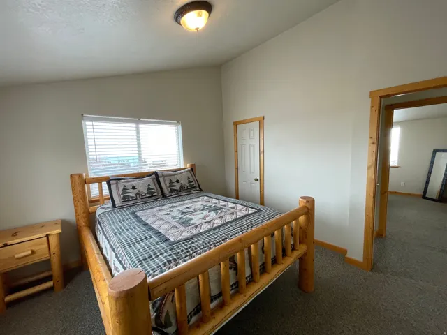 Bedroom featuring vaulted ceiling and carpet flooring